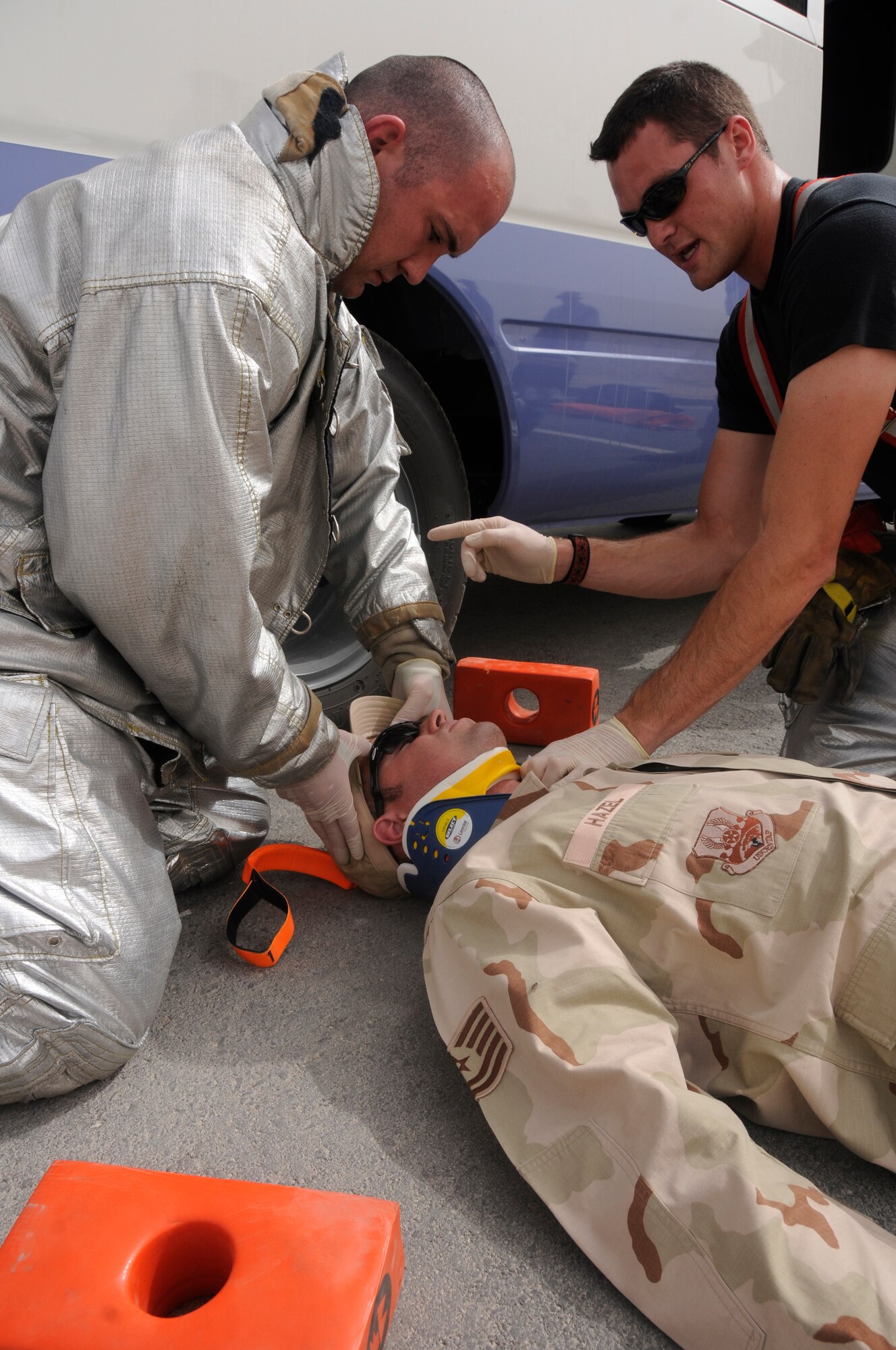 The fire rescue team responds to a simulated emergency during a Major Accident Response Exercise March 20.  The victim, Tech. Sgt. Jeremy Hazel, participates in the exercise with simulated injuries sustained in a vehicle accident. (U.S. Air Force photo/Senior Airman Domonique Simmons)