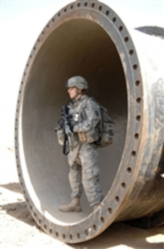 U.S. Army Pfc. Mike Skirkanion uses a large pipe to escape the glare of the sun as he provides security at a water access point in the Taji Qada, Iraq, on March 20, 2008.  Skirkanion is attached to the 1st Battalion, 27th Infantry Regiment, 2nd Stryker Brigade Combat Team, 25th Infantry Division.  