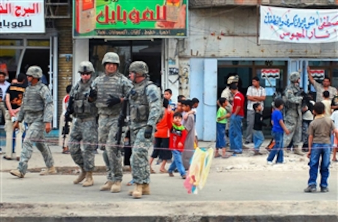 U.S. Army soldiers and Iraqi army soldiers talk with people on Chem Street in Adhamiyah, Iraq, March 20, 2008, after efforts to improve security brought the market back to life. The U.S. soldiers are assigned to the 3rd Infantry Division's 3rd Squadron, 7th Cavalry Regiment.