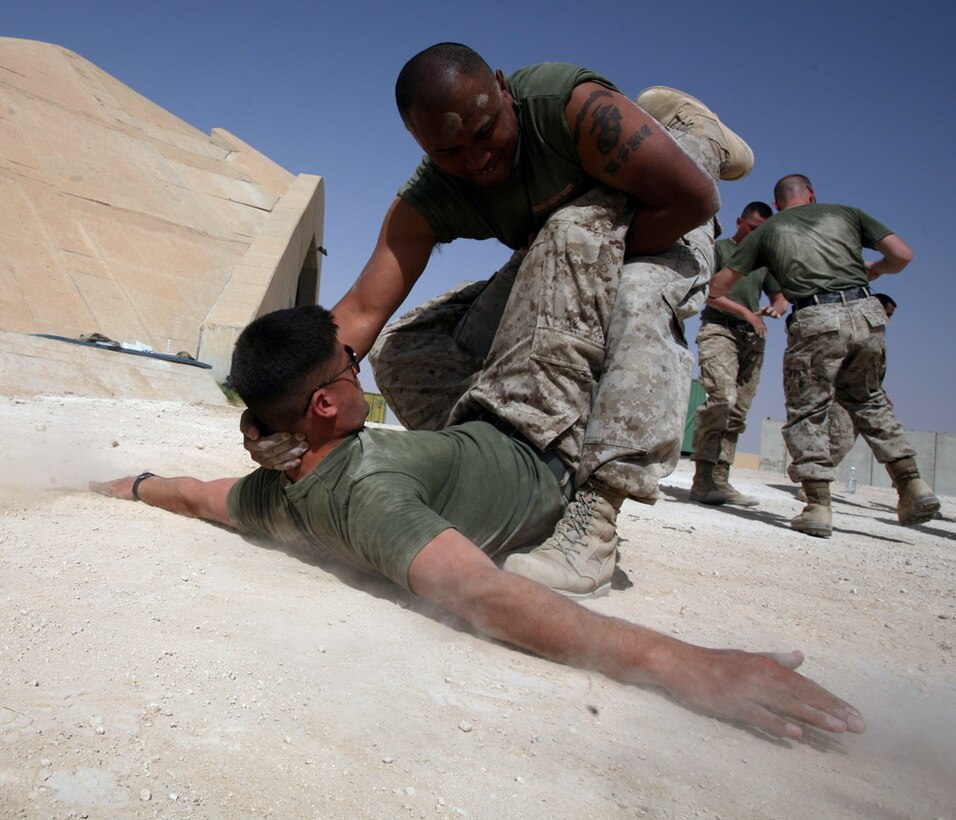 Gunnery Sgt. Manuel Crisologo, the staff noncommissioned officer-in-charge of quality assurance for Marine Fighter Attack Squadron 115 sweeps Sgt. Jason Castro, a ground support equipment mechanic from VMFA-115, while performing a counter to the round kick. The technique is part of the green belt class held on the flight line by VMFA-115. To prevent injuring his partner, Crisologo cradles Castro’s head to help ease the impact of the sweep as Castro uses his arms to break his fall.