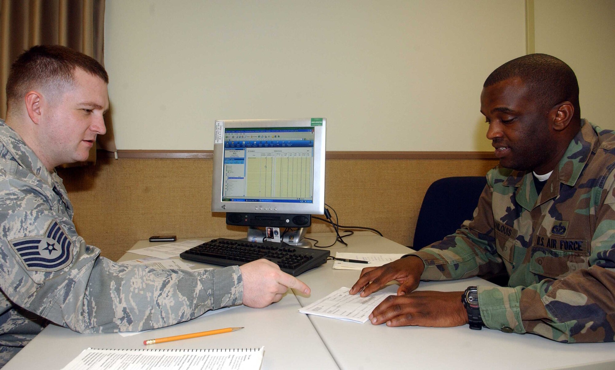 Tech. Sgt. Michael McBride, a tax center volunteer from the 51st Munitions Squadron, discusses itemized tax deductions with Staff Sgt. Rockson Jeanlouis, 51st Civil Engineer Squadron. The tax center offers a variety of free services including electronic filing and preparation of federal income taxes. (U.S. Air Force photo/Staff Sgt. Candy Knight)