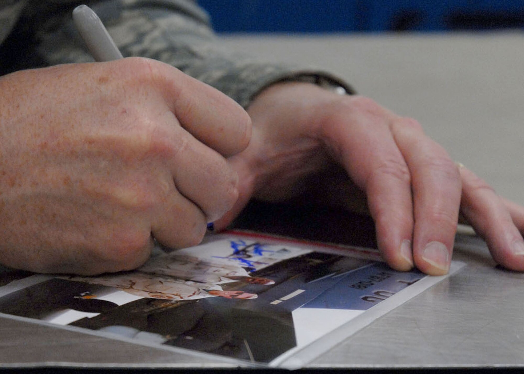 KUNSAN AIR BASE, Republic of Korea-- Chief Master Sergeant of the Air Force Rodney McKinley signs a photograph here during his visit to the base March 24. (U.S. Air Force photo/Staff Sgt. Araceli Alarcon)                                                                         