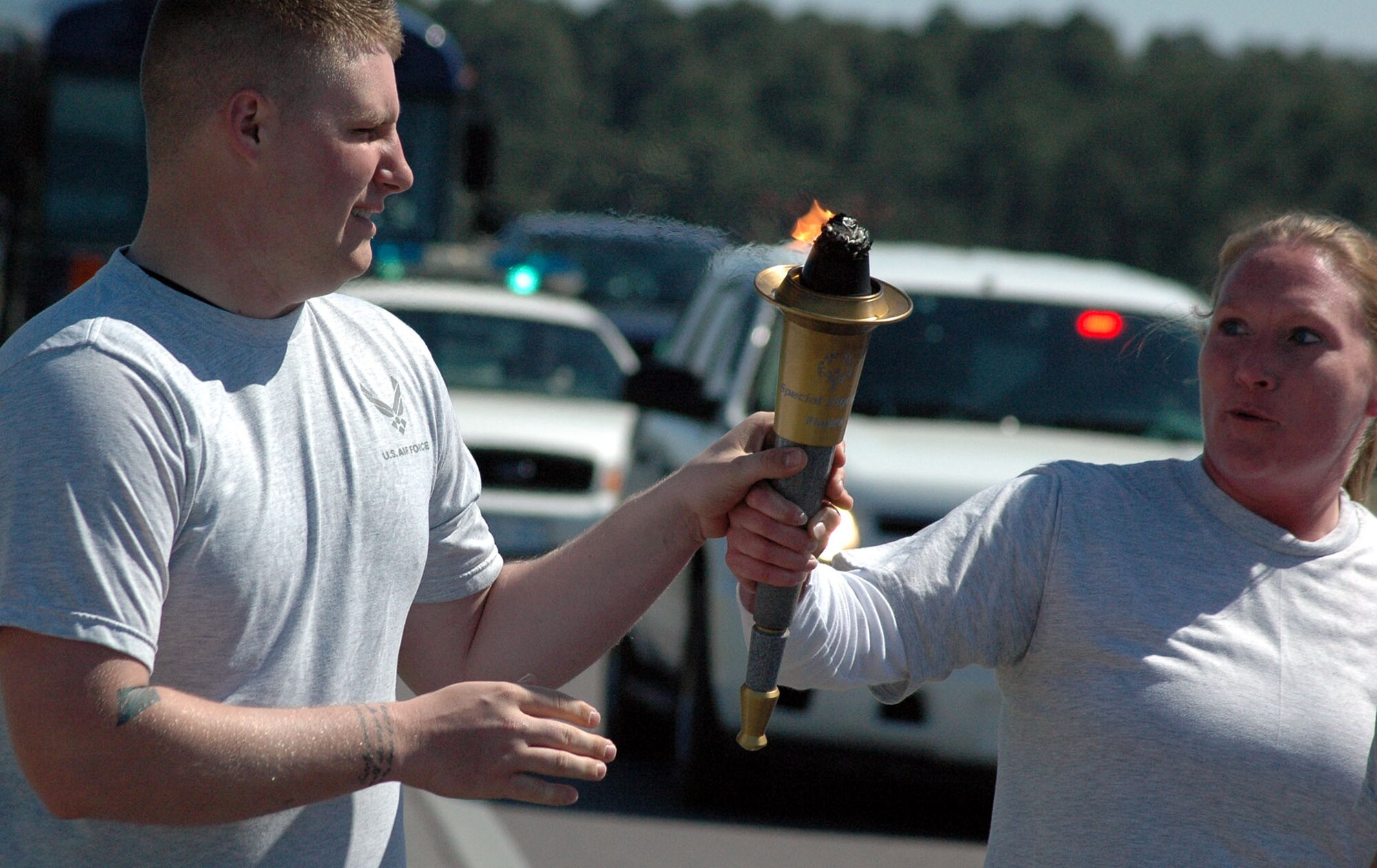 Tech. Sgt. Robert Goddard receives the torch from Tech. Sgt. Michele Stringert midway through The Florida Torch run, a grass roots program supported by local police departments as a fundraiser for the Special Olympics.  (U.S. Air Force Photo by Airman 1st Class Anthony Jennings)