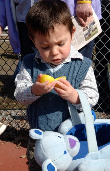 FAIRCHILD AIR FORCE BASE, Wash. – Bradley West, 2, opens an Easter egg during the Annual Children’s Easter Egg Hunt March 22. The multicolored plastic Easter eggs were filled with candy and spread across the tennis court for children to pick up. (U.S. Air Force photo / Airman 1st Class Darlene West)