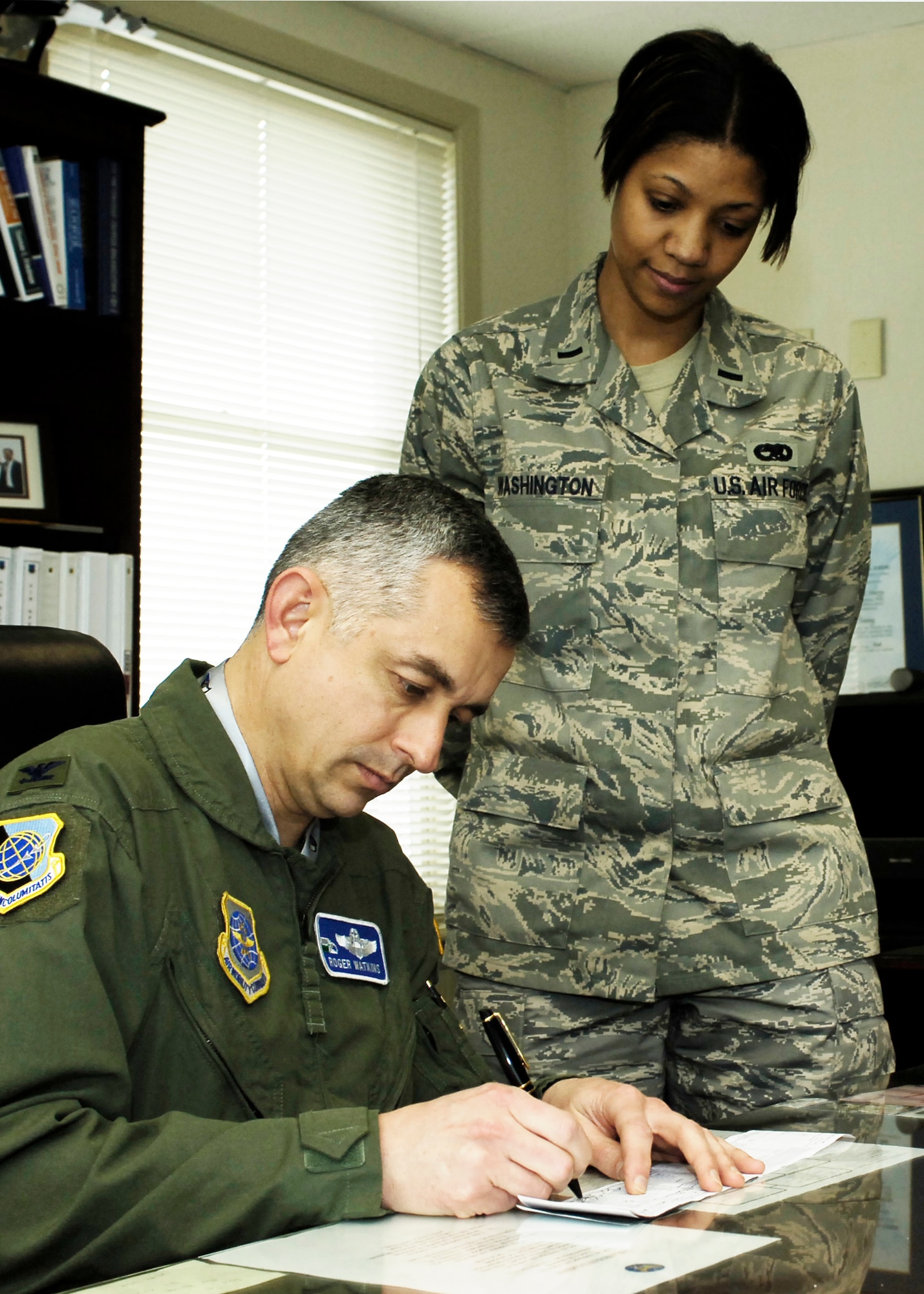 FAIRCHILD AIR FORCE BASE, Wash. – Col. Roger Watkins, 92nd Air Refueling Wing acting commander, signs a donation March12 symbolizing the beginning of the Air Force Assistant Fund as 1st Lt. Tanisha Washington looks on. The AFAF is an annual effort to raise funds for the charitable affiliates that provide support to Air Force families in need. Fairchild’s fund drive runs through April 8. (U.S. Air Force photo / Airman 1st Class Melissa Barnett)