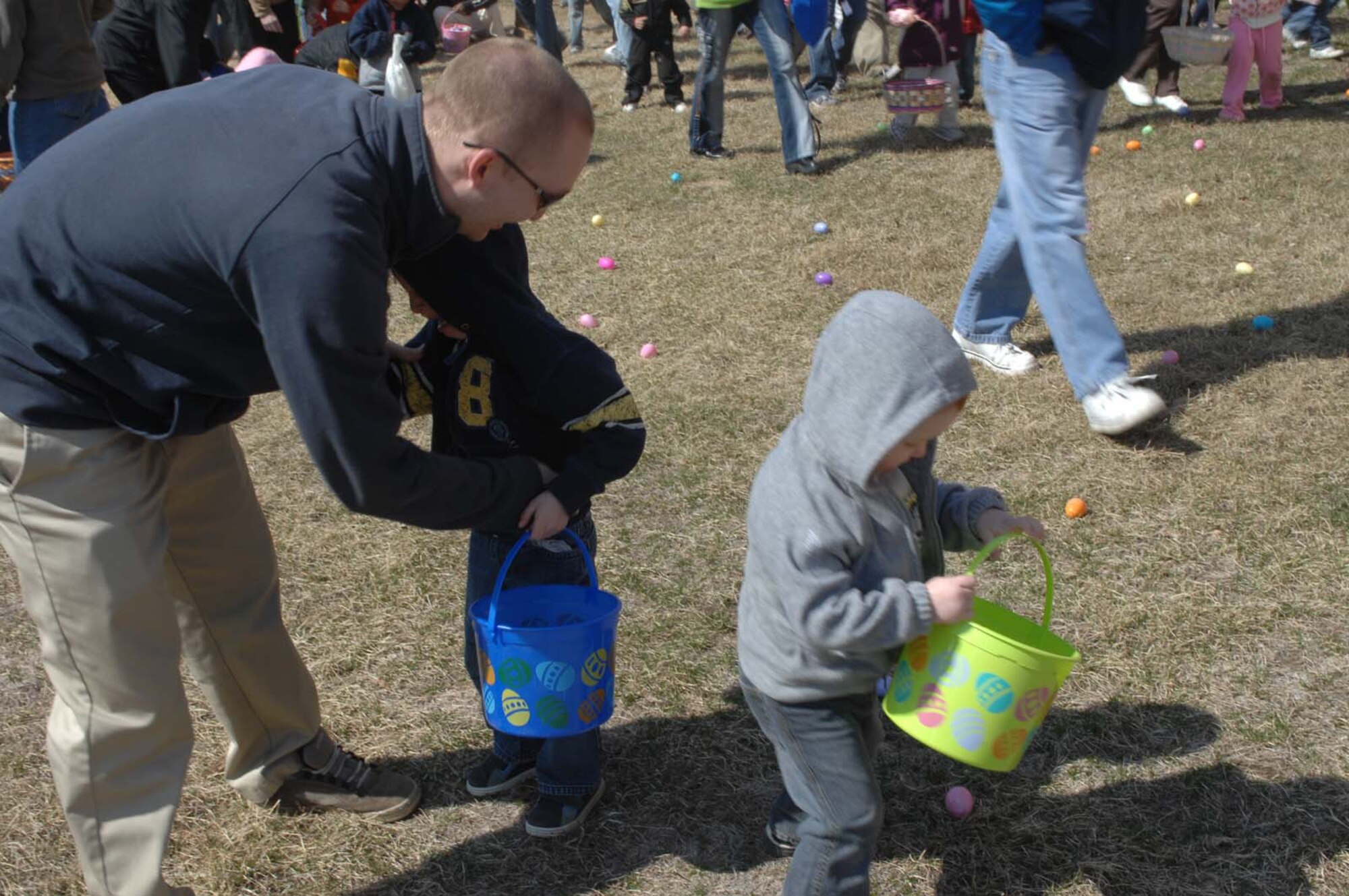 Staff Sgt. Michael Keller, 28th Bomb Wing Public Affairs photographer, helps his two sons, Conall and Cuinn, find Easter eggs at the annual Easter Egg hunt March 22, here.  The Easter Egg hunt was sponsored by Army and Air Force Exchange Service and the 28th Services Squadron.  (Photo by Airman 1st Class Joshua Seybert) 