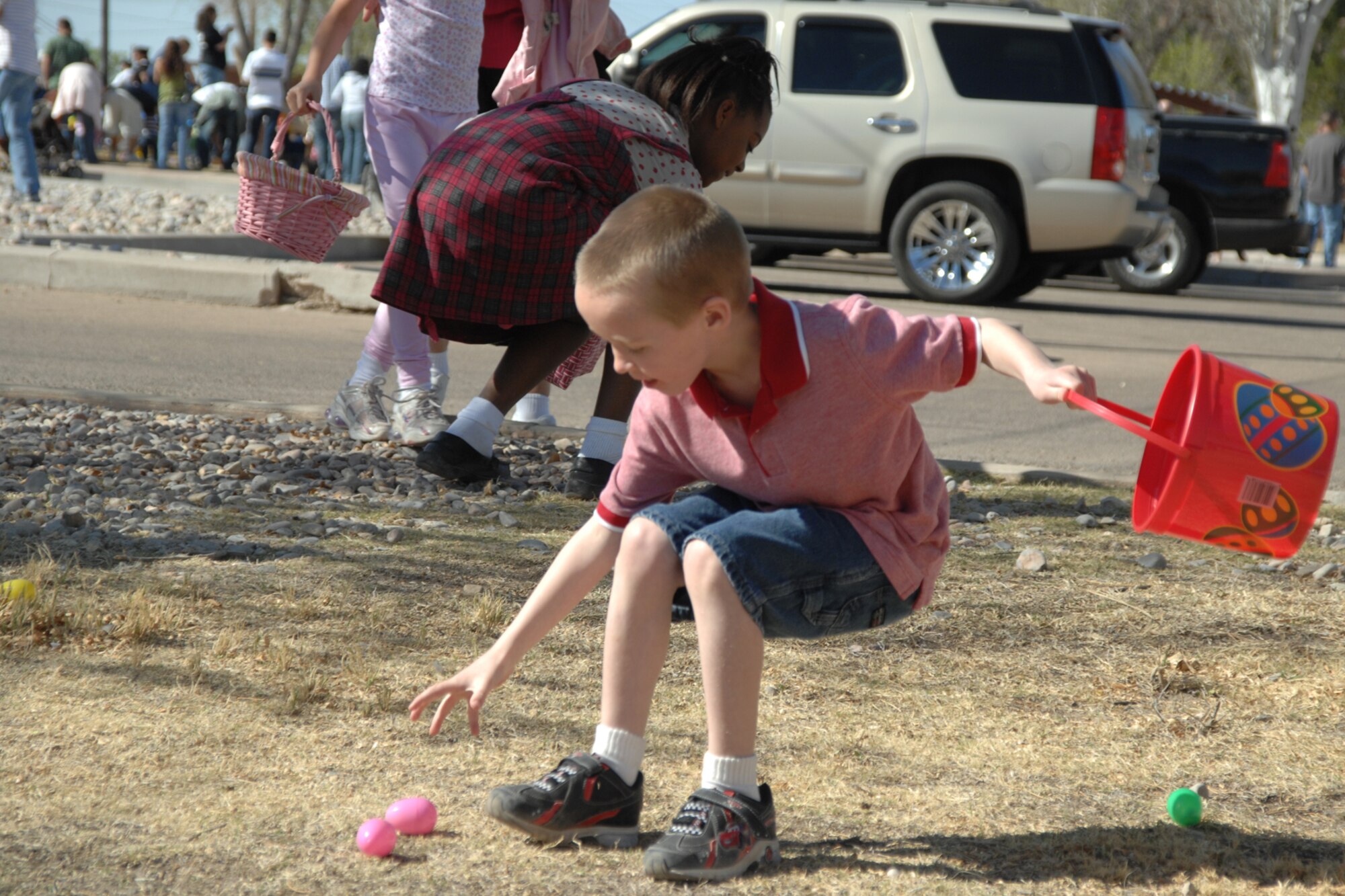 A boy collects eggs during the Base Wide Easter Egg Hunt March 22 at Steinhoff Park, Holloman Air Force Base, N.M. Families with children of all ages showed to take part in the event. (U.S. Air Force photo/Airman 1st Class Jamal D. Sutter)