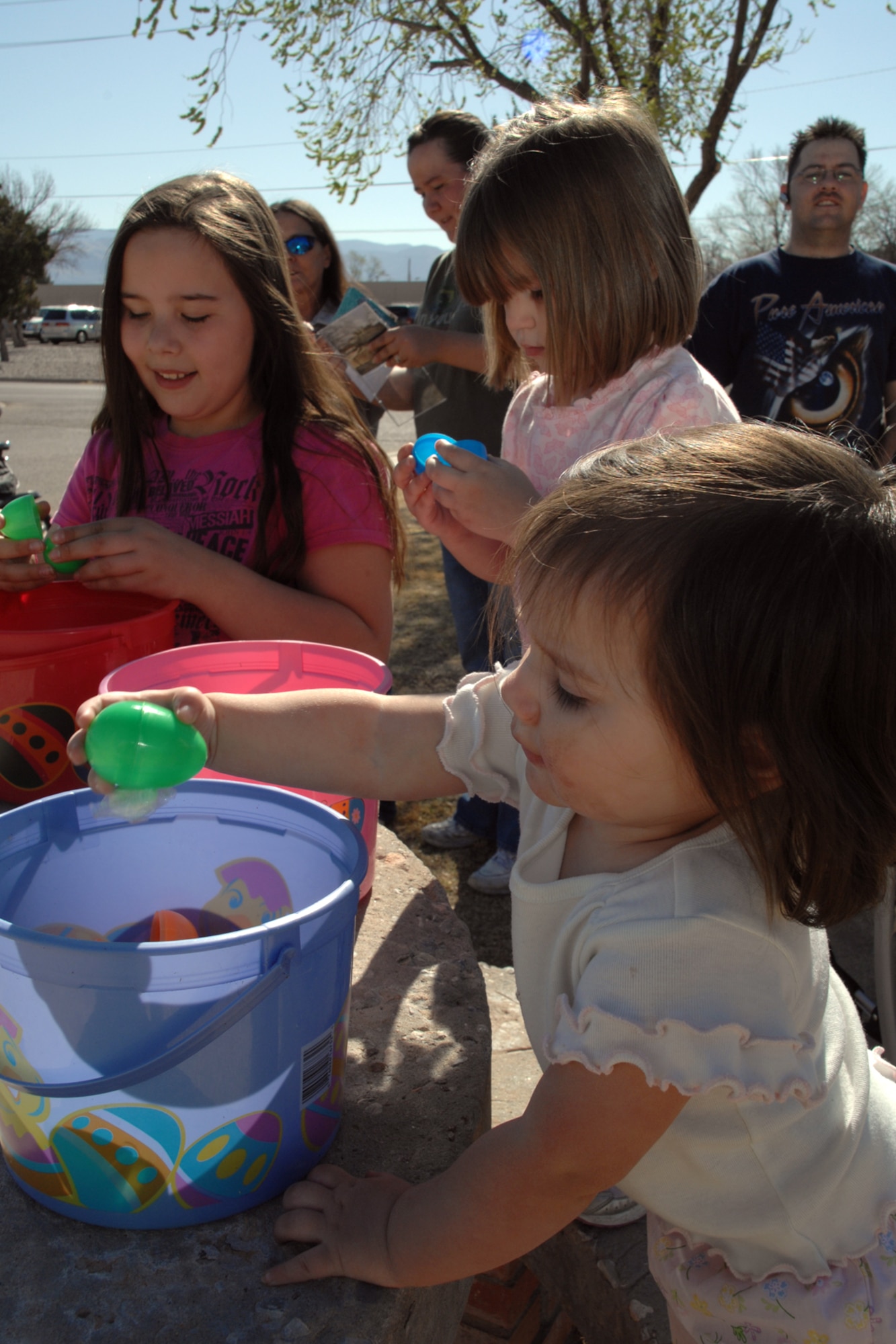 Kaitlynn Neely, 9, Destyn Neely, 3, and Kamryn Neely, 18 months, open their Easter eggs March 22 at Holloman Air Force Base, N.M. Eggs were placed in three sections of Steinhoff park for the different age groups, which were: ages 0-4, 5-7 and 8-12. (U.S. Air Force photo/Airman 1st Class Jamal D. Sutter)