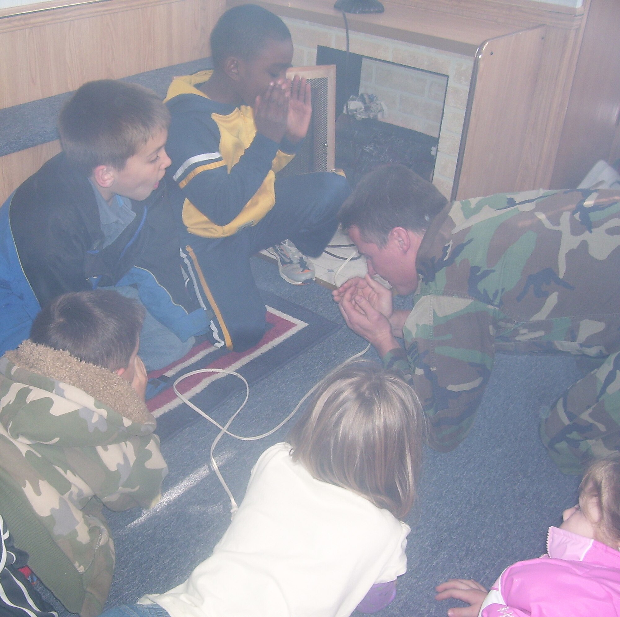 Senior Airman James Scrivener, 509th Medical Group, gives Whiteman youth a lesson on fire safety in a smoky Sedalia Fire Department Fire Safety House during a community helpers event with the Youth Center's School-age Program. The youth center is open 6:30am-6:00pm Monday thru Wednesday, 6:30am-8:00pm Thursday, 6:30am-10:30pm Friday and Saturday is open for special programs.  (Photo printed with permission of Debbie Kermick)