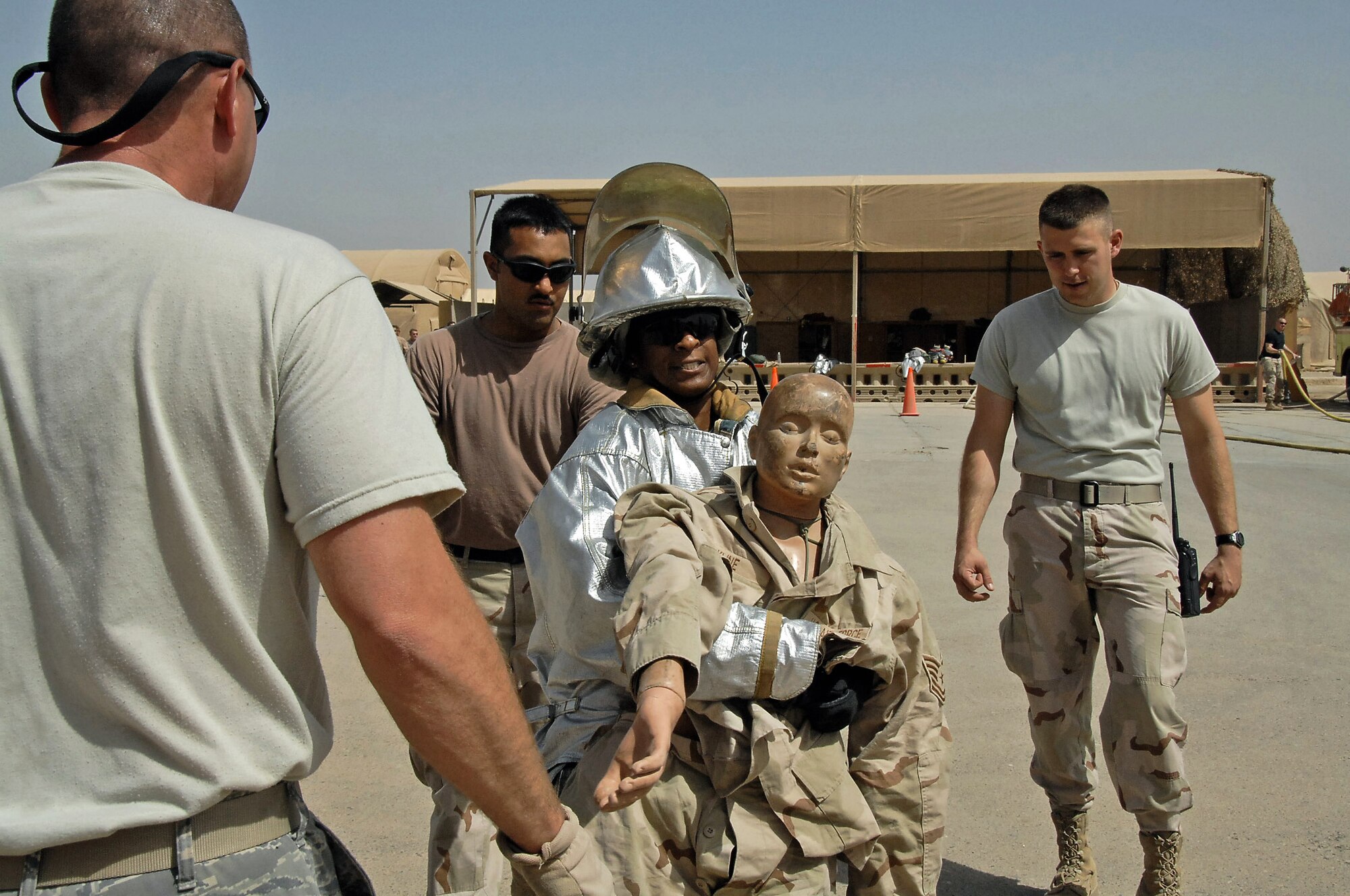 Staff Sgt. David Parker, Senior Airman Peter Franco and Tech. Sgt. Duane Eivins watch an Iraqi firefighter compete in the "firefighter challenge" March 24 at Ali Base, Iraq. The Iraqis had to pass the challenge in under 8 minutes to graduate the Basic Firefighter Skills Course. In this challenge, the firefighter had to drag a rescue dummy 100 feet while walking backward. Sergeant Parker, Airman Franco and Sergeant Eivins are 407th Expeditionary Civil Engineer Squadron firefighters. (U.S. Air Force photo/Tech. Sgt. Sabrina Johnson) 
