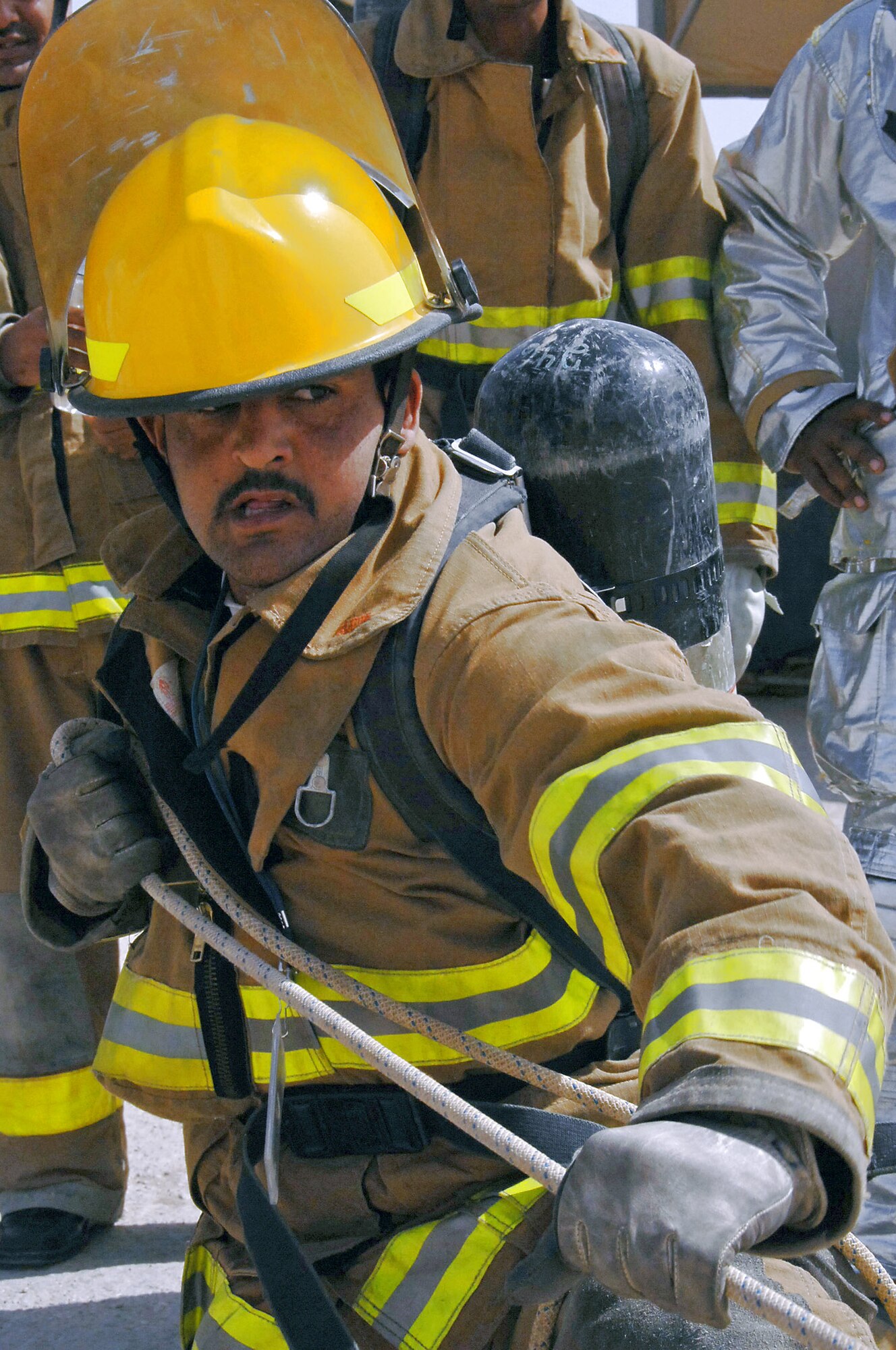 An Iraqi firefighter participates in a "firefighter challenge" March 24 at Ali Base, Iraq. The Iraqis had to pass the challenge in under 8 minutes to graduate the Basic Firefighter Skills Course, conducted by members of the 407th Expeditionary Civil Engineer Fire Department. In this event, the firefighter had to pull hose rolls 25 meters using the hand-over-hand method. (U.S. Air Force photo/Tech. Sgt. Sabrina Johnson) 
