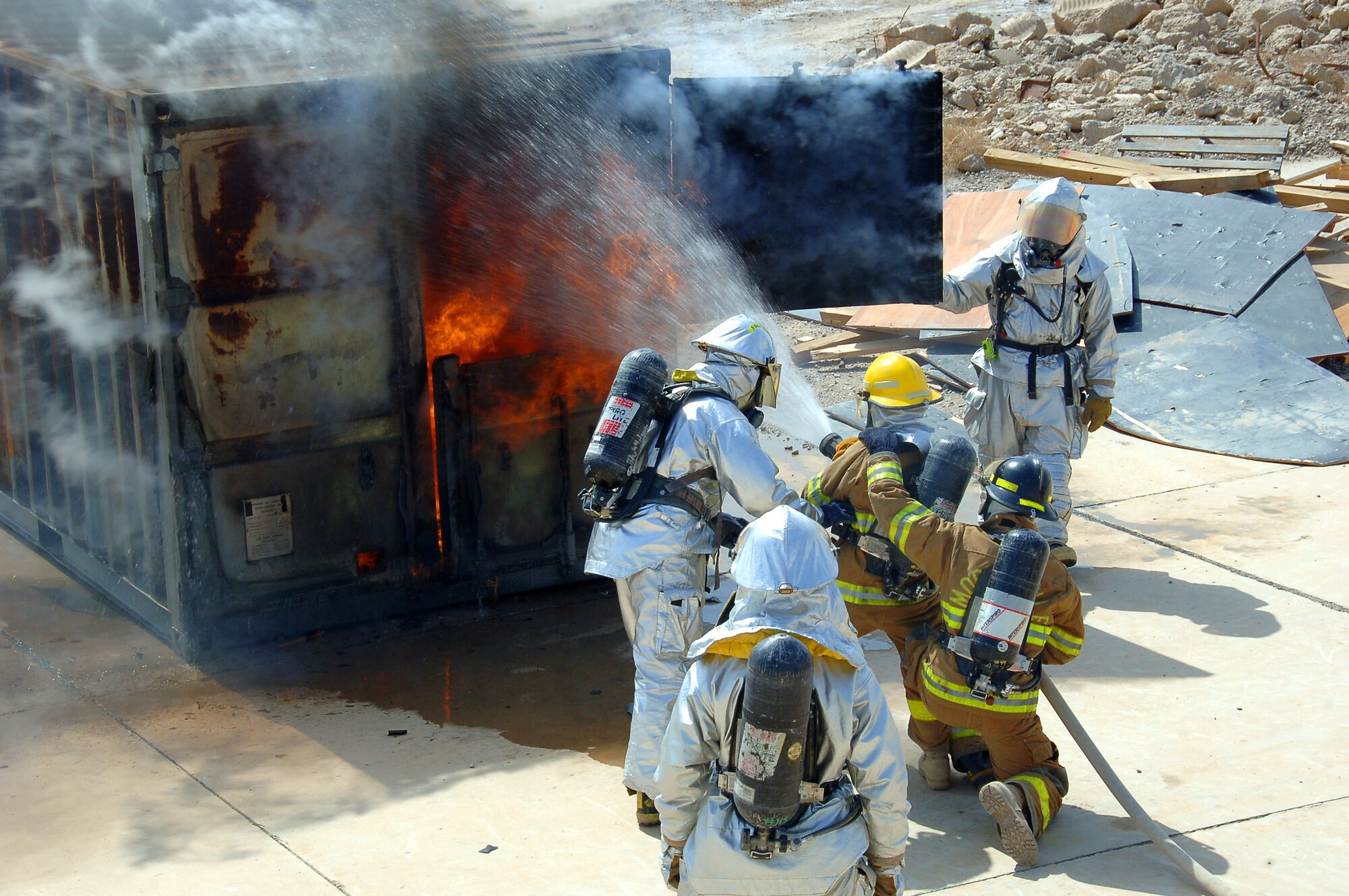 Air Force firefighters from the 407th Expeditionary Civil Engineer Squadron show Iraqi firefighters, in yellow, the proper technique to attack a fire as a team March 3 at Ali Base, Iraq. The Iraqi firefighters attended six, three-block courses to teach them the basics of firefighting. (U.S. Air Force photo/Staff Sgt. Nathan Gallahan) 
