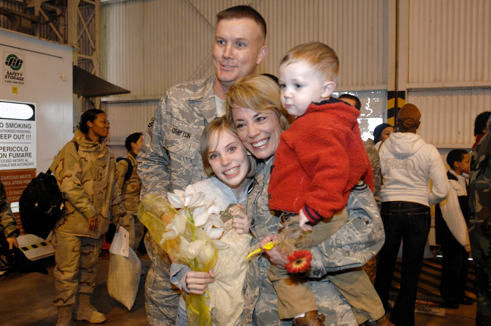 Master Sgts. Chris Crafton and Paige Crafton and their two children Zackary and Taylor embrace each other after Paige's return from a long deployment Jan. 15 at Aviano Air Base, Italy. (U.S. Air Force photo/Airman 1st Class Ashley Wood) 
