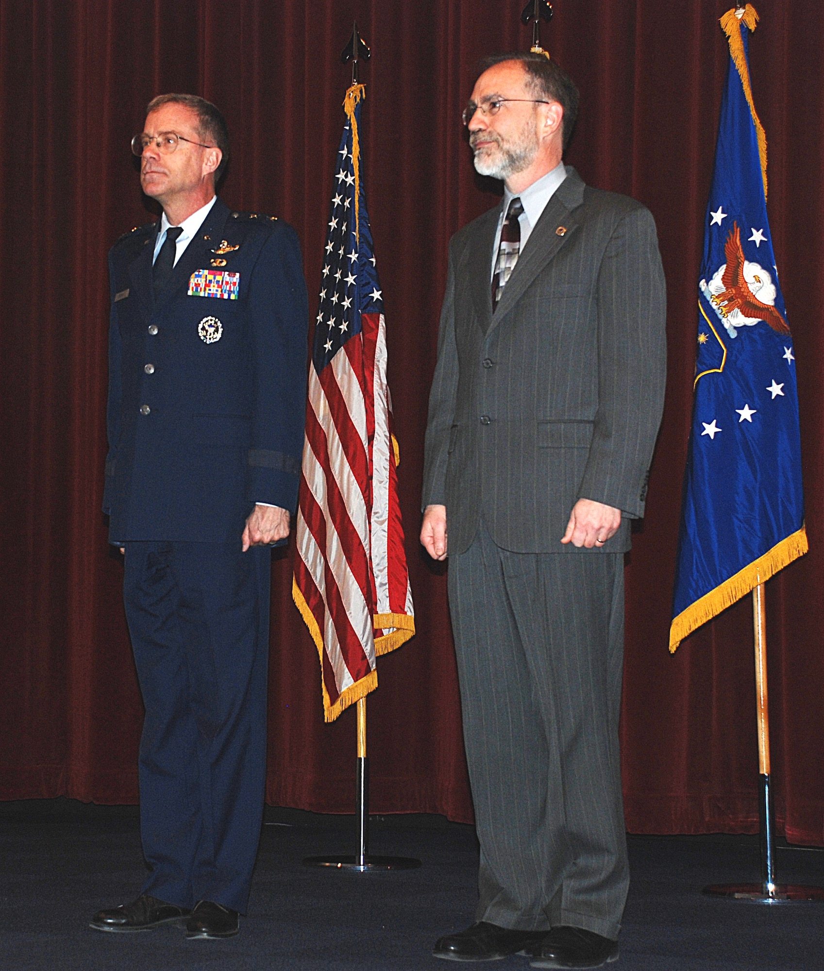Major Gen. Curtis M. Bedke, AFRL Commander, and Mr. Thomas S. Wells, 711th Human Performance Wing Director, stand at attention for the reading of the official order to activate the 711th HPW.  The ceremony was held at the Air Force Institute of Technology's Kenny Auditorium, Wright-Patterson AFB, Ohio, March 25. Photo by Chris Gulliford