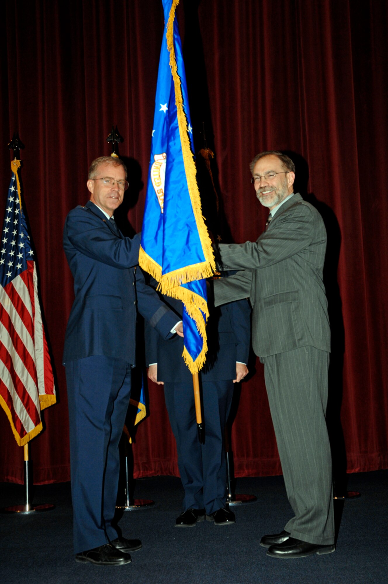 Major Gen. Curtis M. Bedke, Air Force Research Laboratory Commander presents the 711th Human Performance Wing flag to Mr. Thomas S. Wells, 711th HPW Director March 25 during an activation ceremony at Wright-Patterson AFB, Ohio. Photo by Al Bright