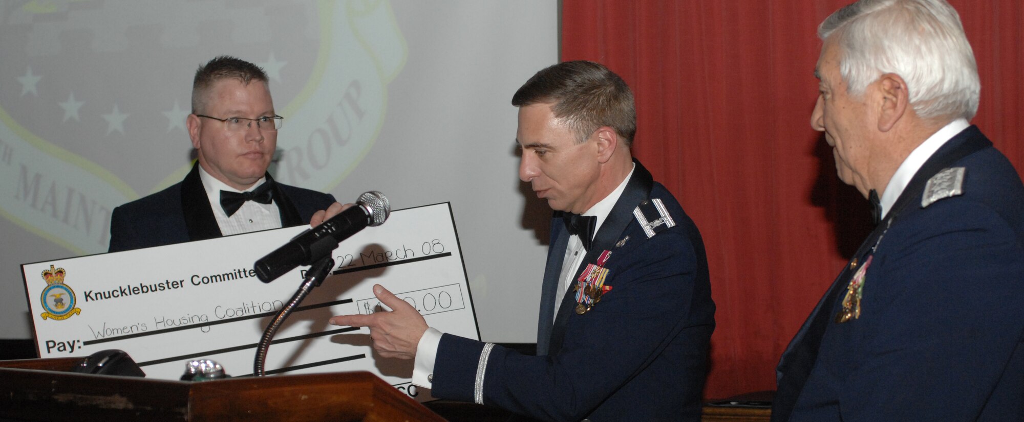 Col. Michael Seville, 100th Maintenance Group commander, presents retired Lt. Gen. Leo Marquez with a $150 donation made in his name by the group to the Women's Housing Coalition. (U.S. Air Force photo by Airman 1st Class Brad Smith)
