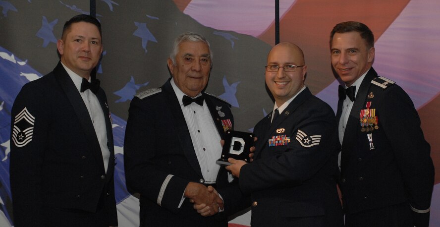 Knucklebuster People's Choice Award NCO Category (from left) Chief Master Sgt. Gregory Blue, 100th Maintenance Group chief enlisted manager; retired Lt. Gen. Leo Marquez; Staff Sgt. Paul Peck, 100th Maintenance Squadron and award recipient; and Col. Michael Saville, 100th Maintenance Group commander. (U.S. Air Force photo by Airman 1st Class Brad Smith) 
