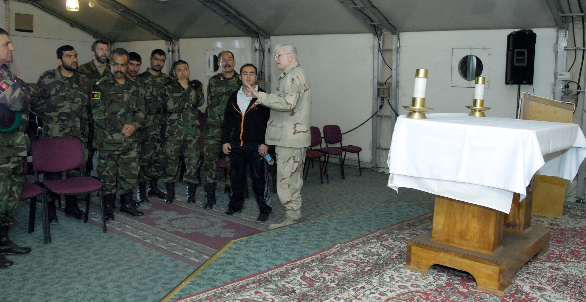 Commanders from the Afghan national army are briefed by Chaplain (Maj.) William Bartoul (right) March 24 at Manas Air Base, Kyrgyzstan. The Afghan commanders, who are transiting Manas AB on their way back from training in Germany, asked for a tour of the facility. Chaplain Bartoul briefed the commanders on the variety of worship available at the base and how base chaplains help facilitate servicemembers of all religions to practice their faith. Chaplain Bartoul is assigned to the 376th Air Expeditionary Wing. (U.S. Air Force photo/Senior Airman Tabitha Kuykendall)