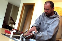 MINOT AIR FORCE BASE, N.D. -- Allan Berdahl, a housing maintenance repair technician with CS DuBois, repairs a kitchen faucet in a house here March 28. The house is undergoing a maintenance phase called "rehab," which consists of plumbing inspections and fixing major damages, before another tenant moves in. (U.S. Air Force photo by Airman 1st Class Kelly Timney)