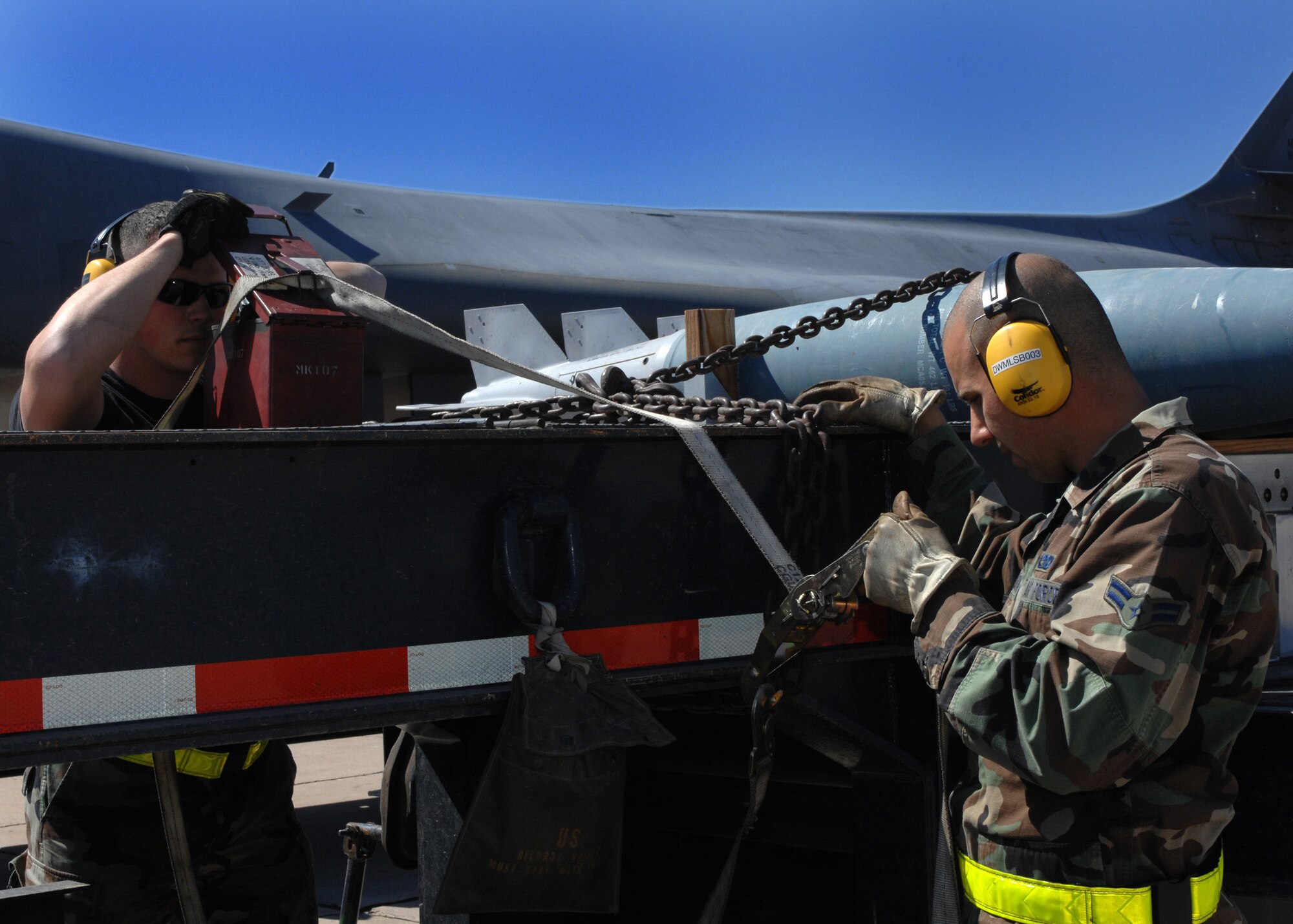 DYESS AIR FORCE BASE, Texas -- Airman 1st Class Adam Aleweidat, 7th Munitions Squadron, waits to secure a container while Senior Airman Scott Williams, 7th MUNS, makes sure that everything is accounted for. B-1 Lancer bombs are transported by flat bed trucks back to storage after unloading. (U.S. Air Force photo by Senior Airman Courtney Richardson)