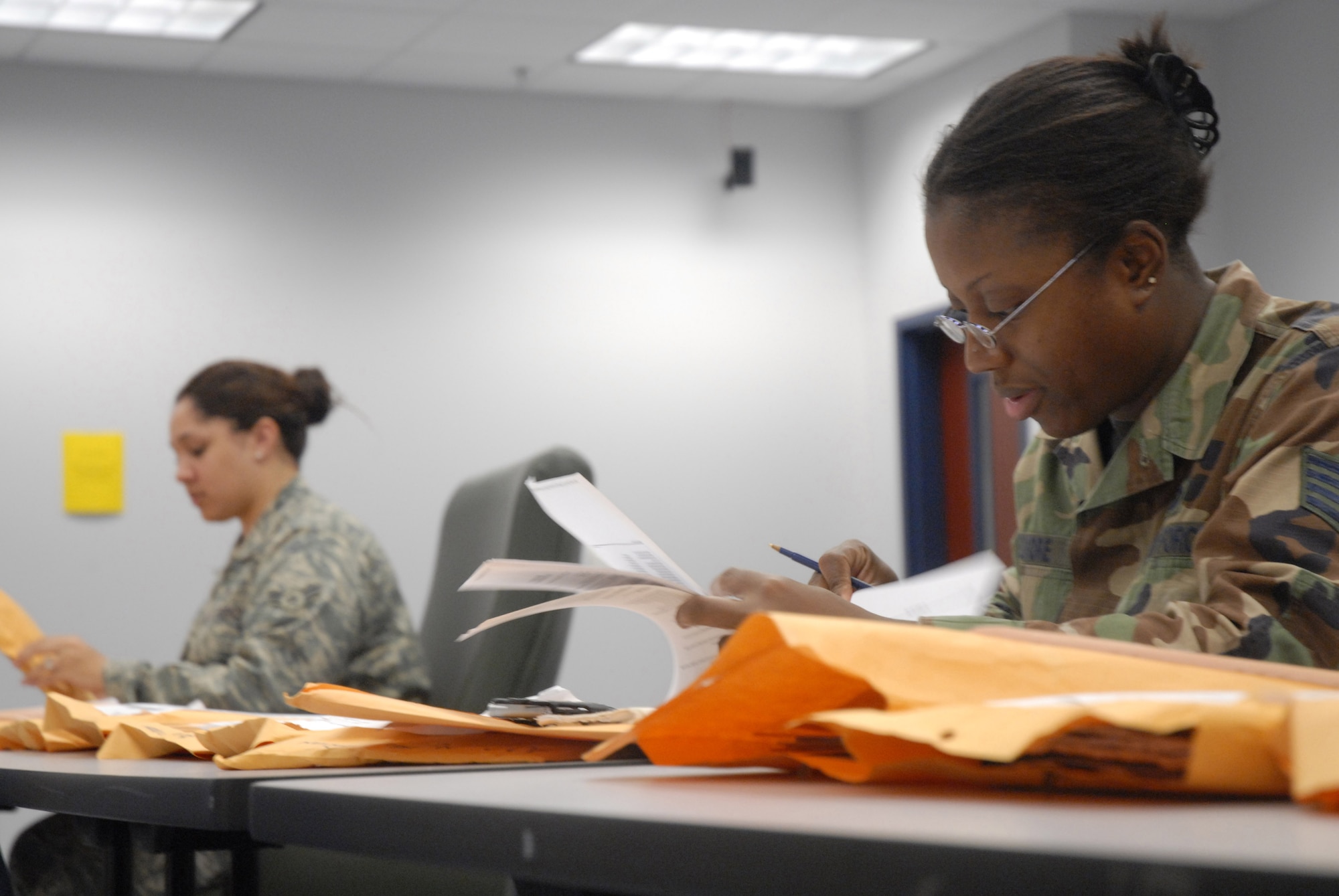 Airman 1st Class Kyrie Redd (left) and Staff Sgt. Tonya Elmore (right) look through deployment folders during the Mobility Exercise Crisis Look 08-03. Members from the 437th Mission Support Squadron inspected more than 330 folders during the exercise to make sure members who were deploying were leaving with the proper documents.  Airman Redd is a customer service apprentice and Sergeant Elmore is the NCO in charge for officer promotions, both are with the 437 MSS. (U.S. Air Force photo/Staff Sgt. Jennifer Arredondo)