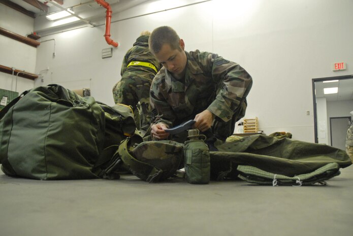 Senior Airman Bradley Saari inspects his field-gear equipment bag during the Mobilty Exercise Crisis Look 08-03 at the 437th Logistics Readiness Squadron Personnel Deployment Facility March 19.  Bags are inspected during the deployment process to make sure Airmen have all required equipment and that it is serviceable. Airman Saari is with the 437th Aerial Port Squadron. (U.S. Air Force photo/Staff Sgt. Jennifer Arredondo)