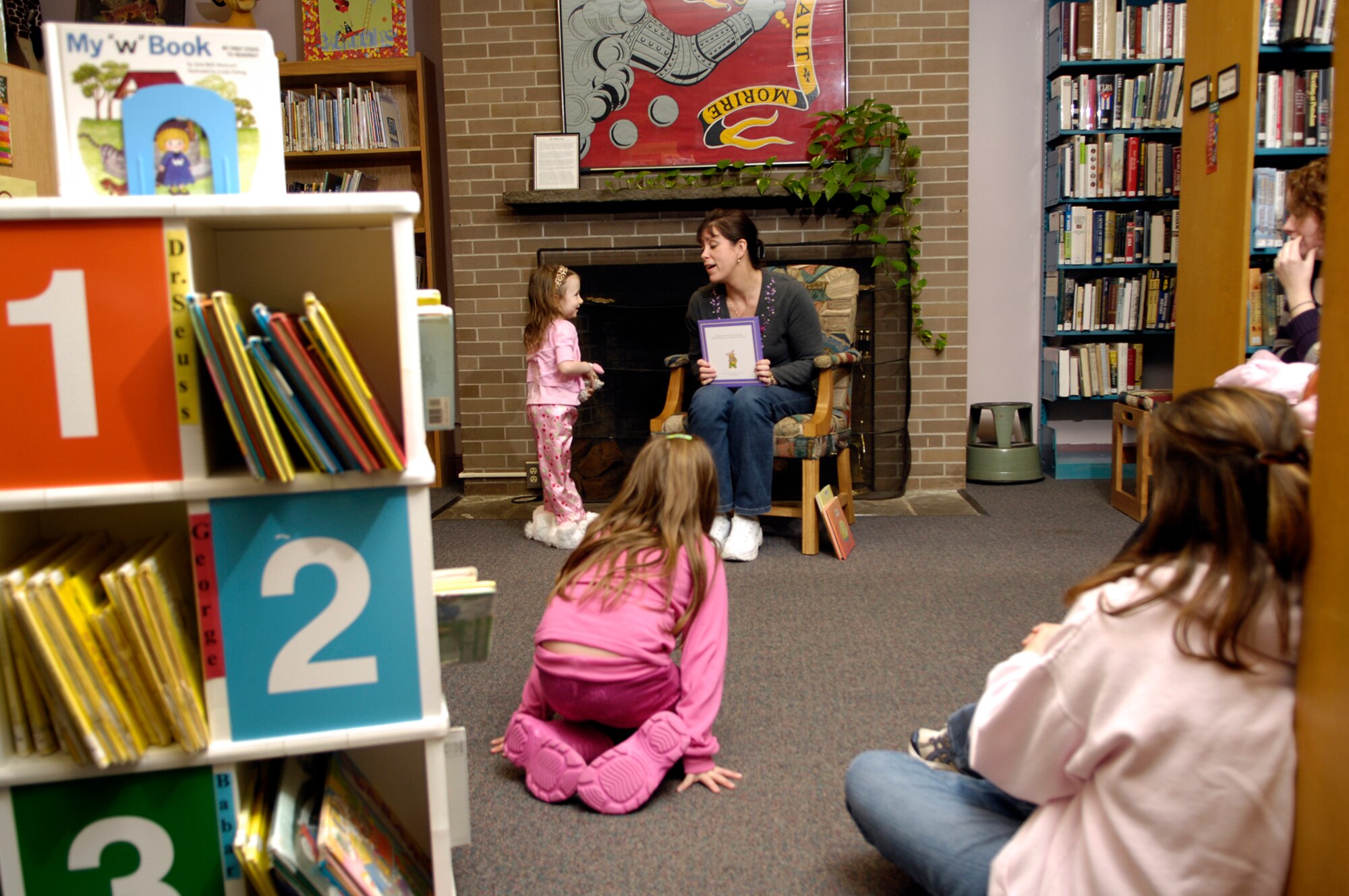 HANSCOM AFB, Mass. – Eve Peabody (center seated in chair), 66th Services Squadron prepares to read a story during pajama story time at the Base Library on March 19. Children snuggled up in their PJs to listen to stories and then took part in some Easter craft activities during the event. For more information on upcoming library activities go to www.hanscomservices.com. (U.S. Air Force photo by Mark Wyatt)