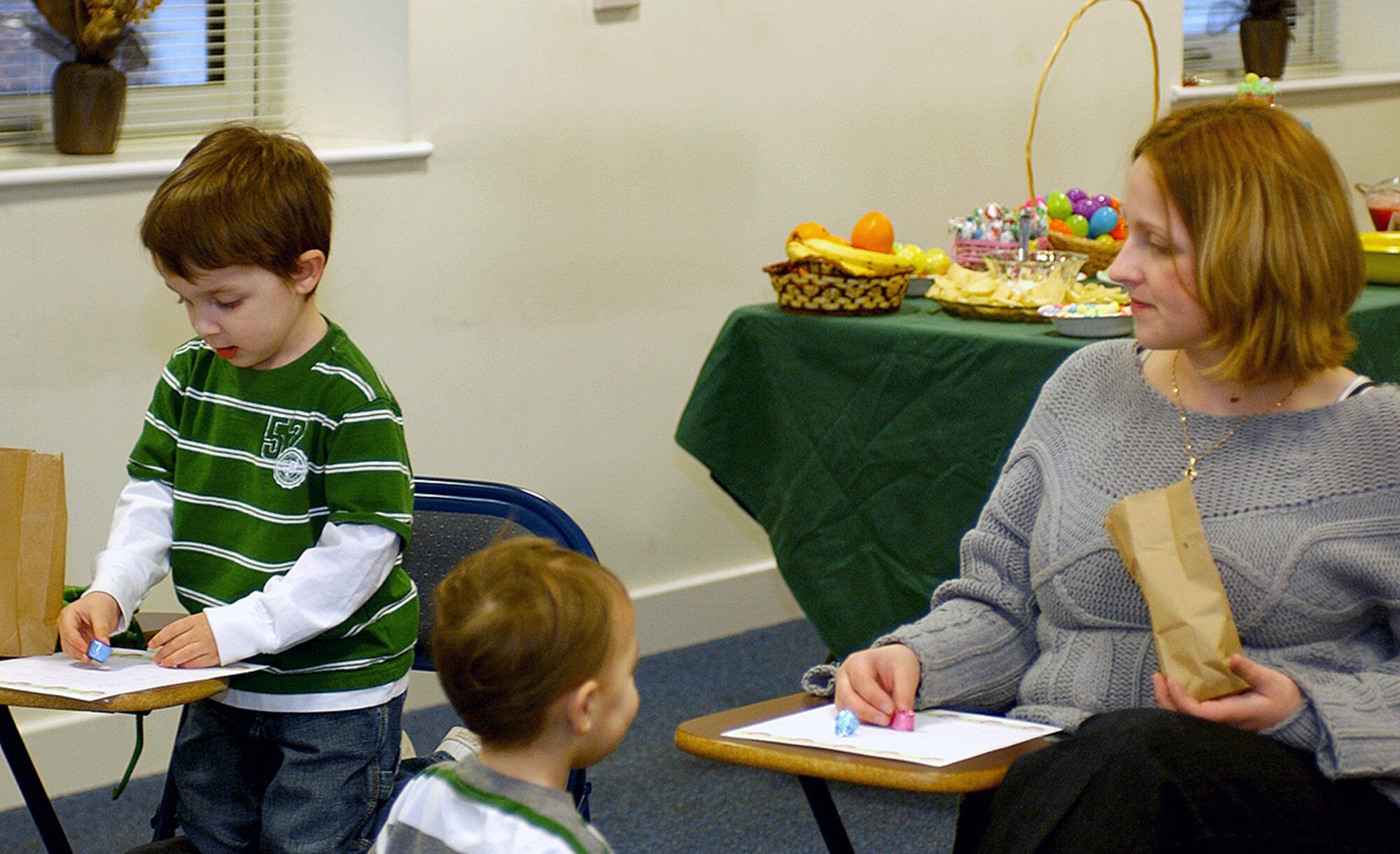 Heather Rodriguez and her two sons, Kendall and Dominique, play Easter Bingo at the Airman and Family Readiness Center on RAF Lakenheath, England March 20. The AFRC offers several activities and support services to the families of deployed Airmen. The Rodriguez family enjoyed fun, food and games as part of a deployed spouses and family social. (U.S. Air Force photo by Airman 1st Class Torri Ingalsbe)