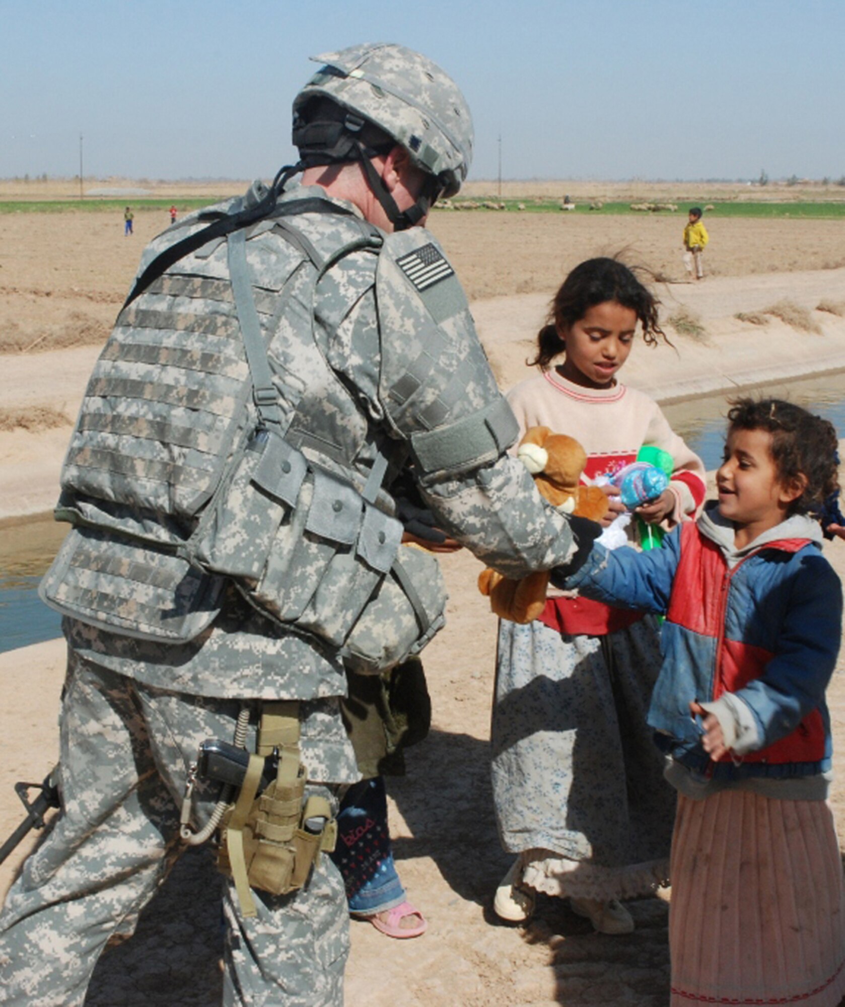 BALAD AIR BASE, Iraq -- An Army Soldier distributes items donated by Balad personnel to Iraqi children near Balad Air Base recently. Since February 2008, the base has donated more than 15,000 items weighing more than 3,000 pounds, which were collected by 727th Expeditionary Air Control Squadron "Kingpin" personnel, for distribution to the local population. The collection effort was spearheaded by 2nd Lt. Sarah Flackus, 727 EACS company grade officer, who is deployed from the 728th Air Control Squadron, Eglin Air Force Base, Fla. (U.S. Air Force courtesy photo)