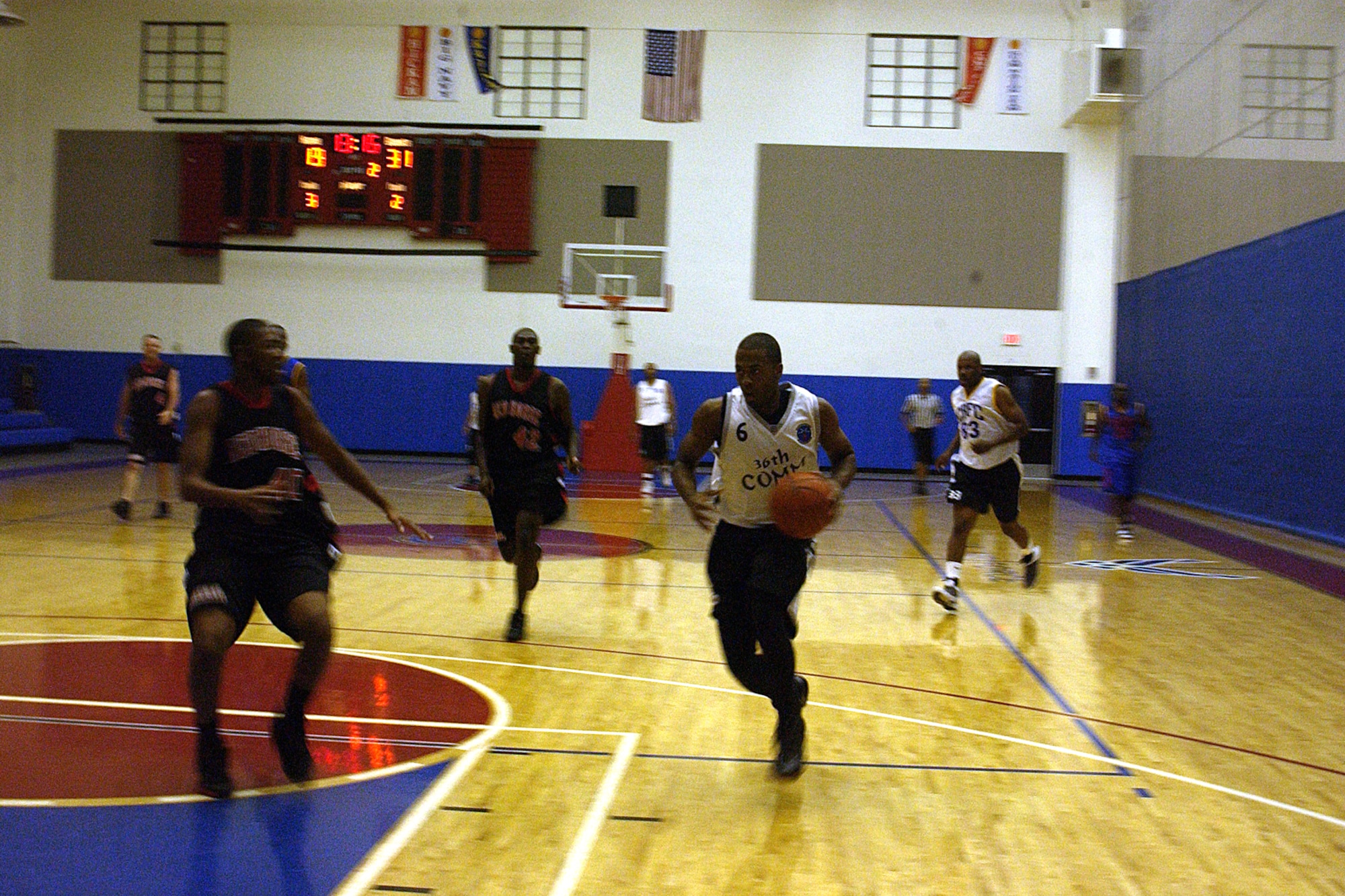 Airman 1st Class Don Morrell, 36th Wing Command Post dribbles to the basket as  Senior Airman Gregory Stewart, 554 REDHORSE Squadron guards him during the championship game of the intramural basketball league here at Andersen. The 36th Communications Squadron has won championships 3 years in a row. (U.S. Air Force photo by Airman 1st Class Carissa Wolff) 