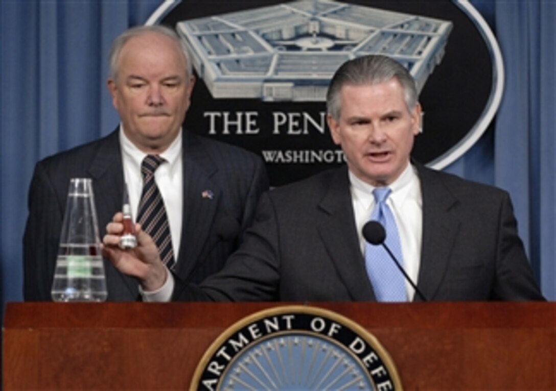 Principal Deputy Under Secretary of Defense for Policy Ryan Henry (right) holds up part of a mock nose cone assembly for a Minuteman missile during a press briefing with Air Force Secretary Michael W. Wynne at the Pentagon in Arlington, Va., on March 25, 2008.  Henry and Wynne described to reporters how some non-nuclear nose cone assemblies were mistakenly sent to Taiwan in 2006 and the immediate effort to regain control of the assemblies once the errant shipment was discovered.  