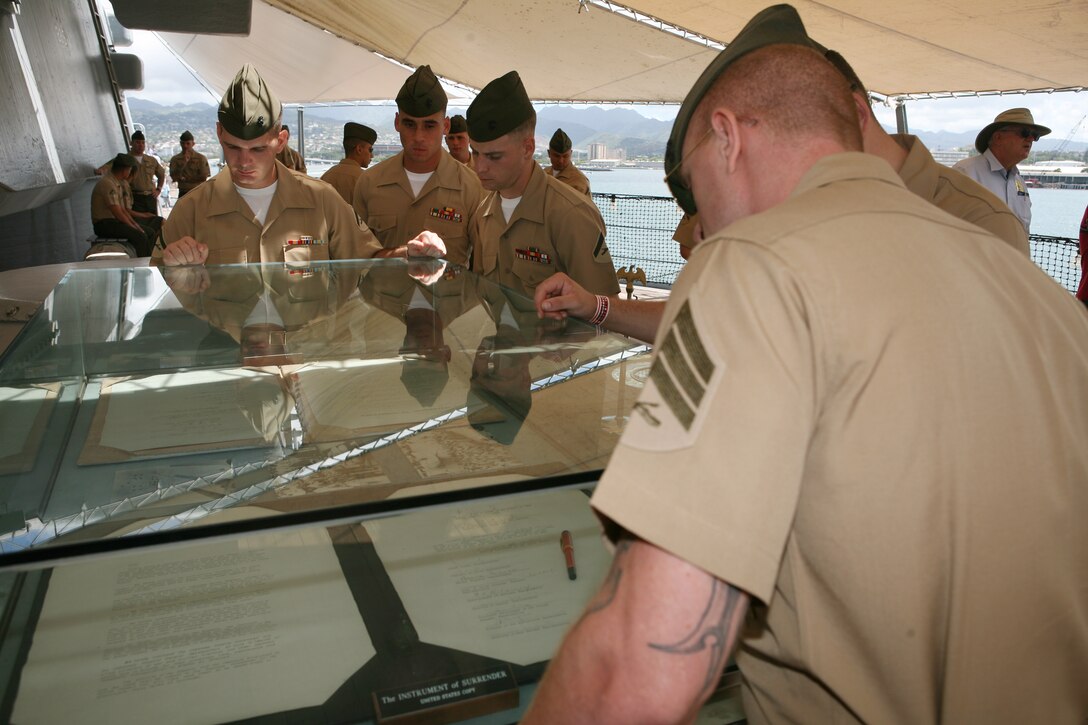 HONOLULU -- Sgt. Robert Manion, nuclear, biological and chemical chief, S-3, Headquarters and Service Battalion, U.S. Marine Corps Forces, Pacific, (right) gazes through the glass shielding the document that finalized the end of WWII during a professional military education on the USS Missouri at Ford Island, March 26. (Official Marine Corps photo by Lance Cpl. Ronald W. Stauffer)