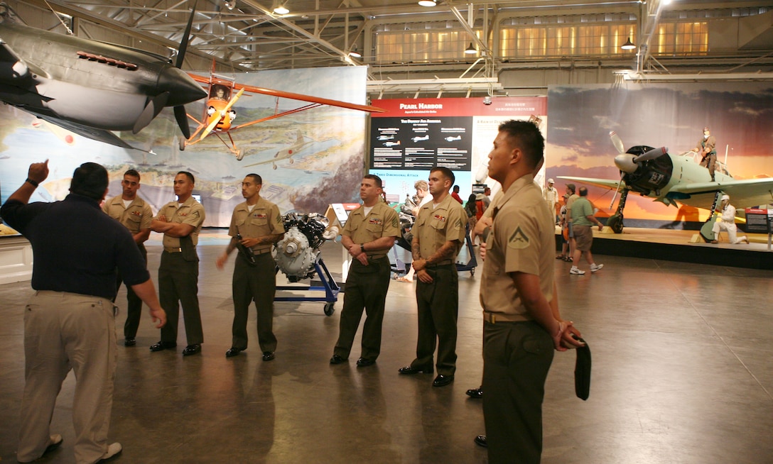 Marines from Camp H.M. Smith view the restored fighters of the sky as Ford Ebesugawa, docent, Pacific Aviation Museum, leads them through a historical tour of the attack on Pearl Harbor during a PME at the  Pacific Aviation Museum on Ford Island, March 26.