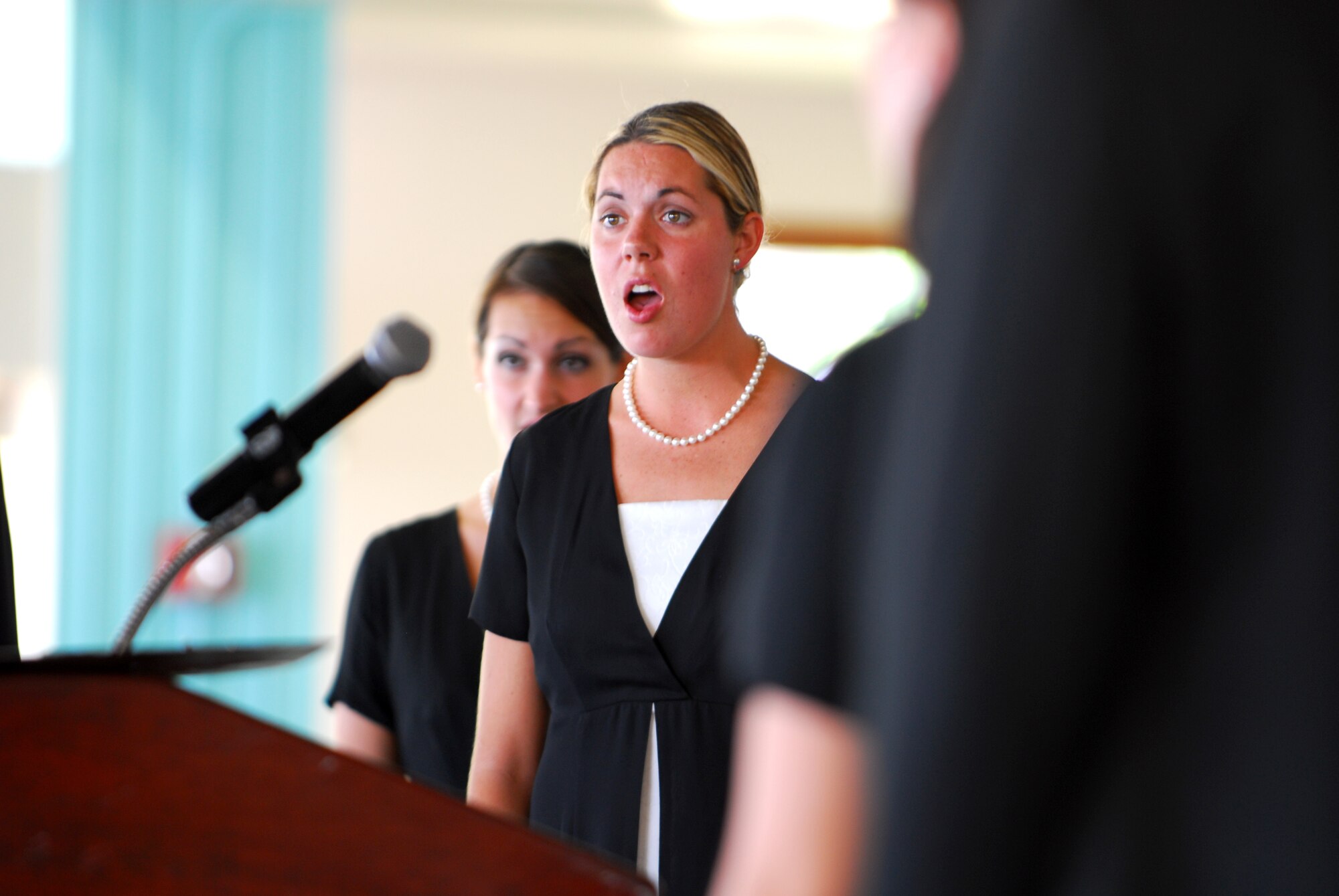 Lauren Woodbury, a junior at Brigham Young University, and 18 members of the BYU choir sing at the beginning of the National Prayer Luncheon, Mar. 25 at the Officers Club Lanai. U.S. Air Force Photo/Staff Sgt. Erin Smith