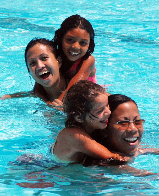 SOTO CANO AIR BASE, Honduras--Volunteering at the swimming pool, Tech. Sgt. Hazel Lawton and Staff Sgt. Maria Maramba provide transportation for some friends during the orphanage visit March 21. More than 60 children from an orphanage in Comayagua, Honduras, visited the men and women of Joint Task Force-Bravo for day of food, fun and camaraderie. (U.S. Air Force photo by Tech. Sgt. William Farrow) 