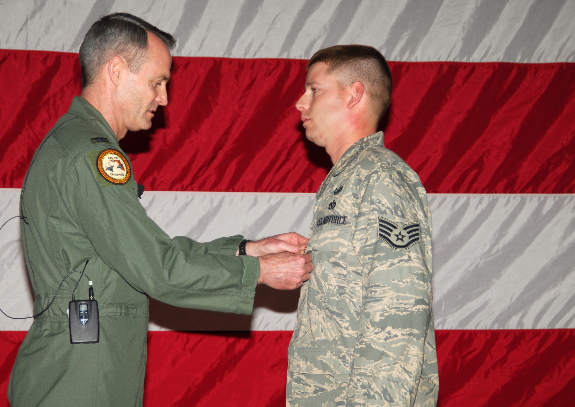 Col. Darryl Roberson, 325th Fighter Wing commander, pins the Air Force Combat Action Medal to Staff Sgt. Jonathon Morrison, 325th Civil Engineer Squadron explosive ordinance disposal craftsman, during the Commander’s Call ceremony here March 14.  (U.S. Air Force photo/Lisa Norman)