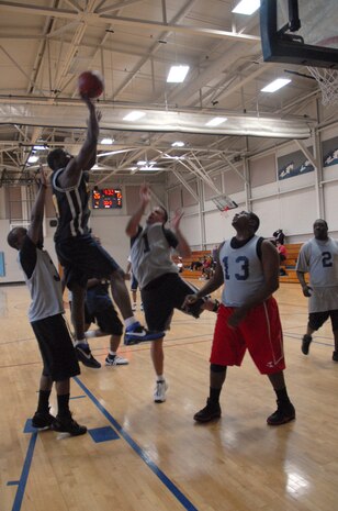 Surrounded by APS defenders, Clinton Coleman, SVS player, shoots the ball during the second half of the intramural basketball game Tuesday. SVS won the game 69-34. (U.S. Air Force photo/Senior Airman Sam Hymas)