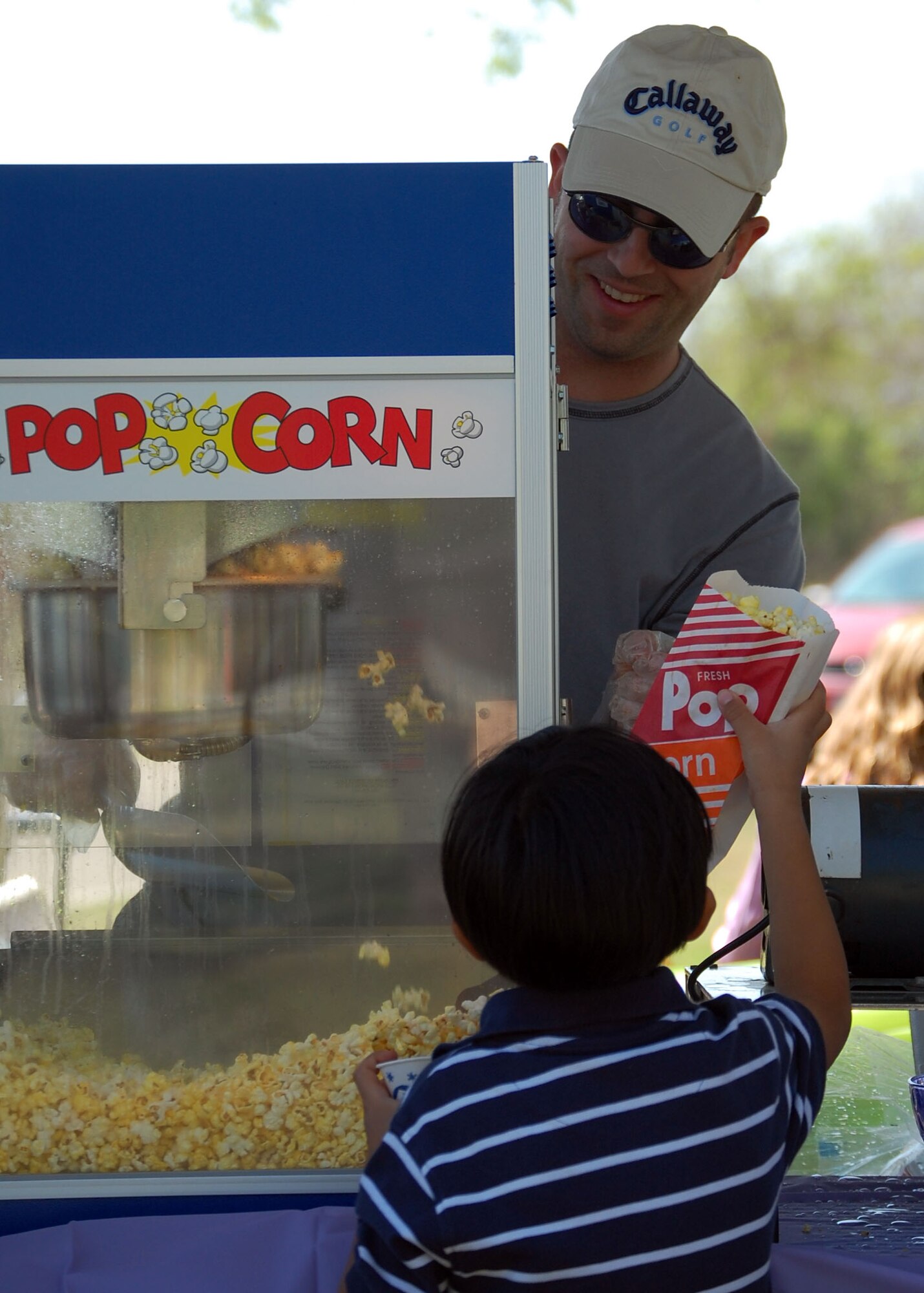 LAUGHLIN AIR FORCE BASE, Texas – A Laughlin volunteer hands a complimentary bag of popcorn, to a child during the Laughlin Youth Center’s Annual Spring Family Day March 22. “In over five years of working youth programs and base-wide events, this has to be one of the smoothest events we ever coordinated!  Lots of people, fun games, great weather, awesome volunteers, tasty food; things just fell into place,” said Ray Torres, Youth Center director. (U.S. Air Force photo by Airman Sara Csurilla)