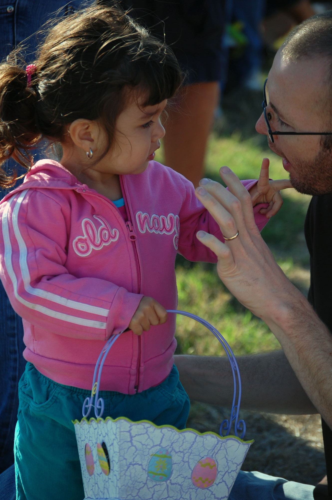 LAUGHLIN AIR FORCE BASE, Texas –Victoria Sinclair, two, daughter of Staff Sgt. Michael Sinclair, 47th Operations Support Squadron and Maria Sinclair, talks to her father before she heads out into the field to collect as many eggs as she can during Laughlin Youth Center’s Annual Spring Family Day March 22. The family day began with a parade that ran from the base chapel to the picnic grounds and continued with an egg hunt and other family oriented games. (U.S. Air Force photo by Airman Sara Csurilla)