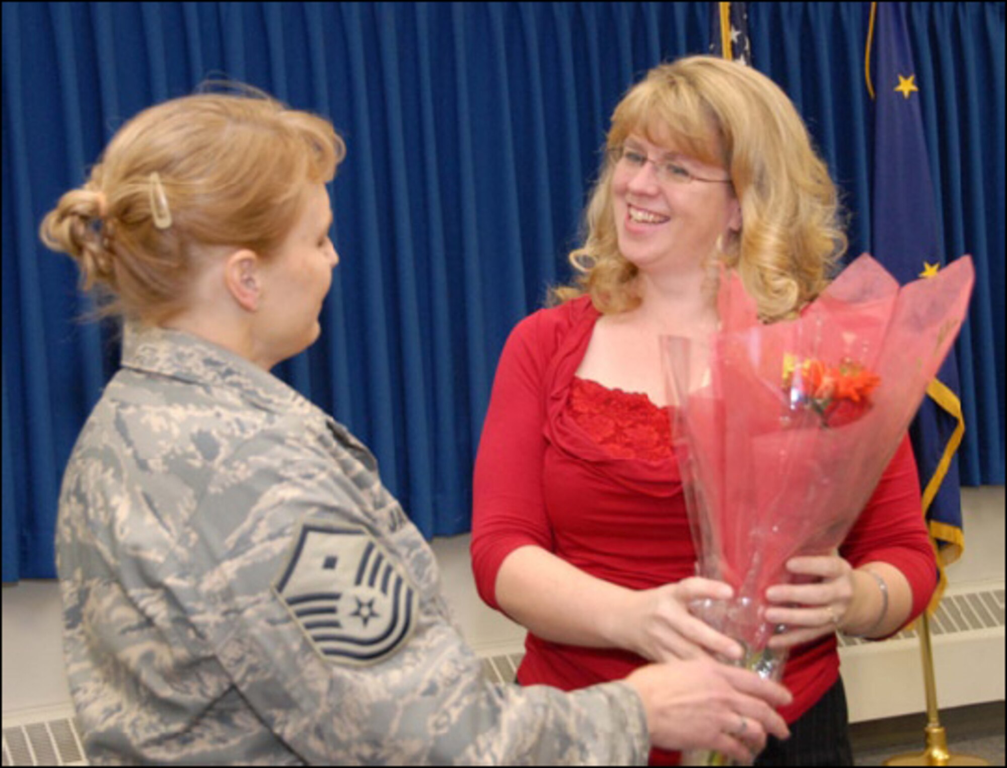Saying “thanks” with a bouquet. 176 CES First Sergeant Barbara Jackson presents Colette Moring with flowers for providing more than 300 Christmas stockings to deployed troops.