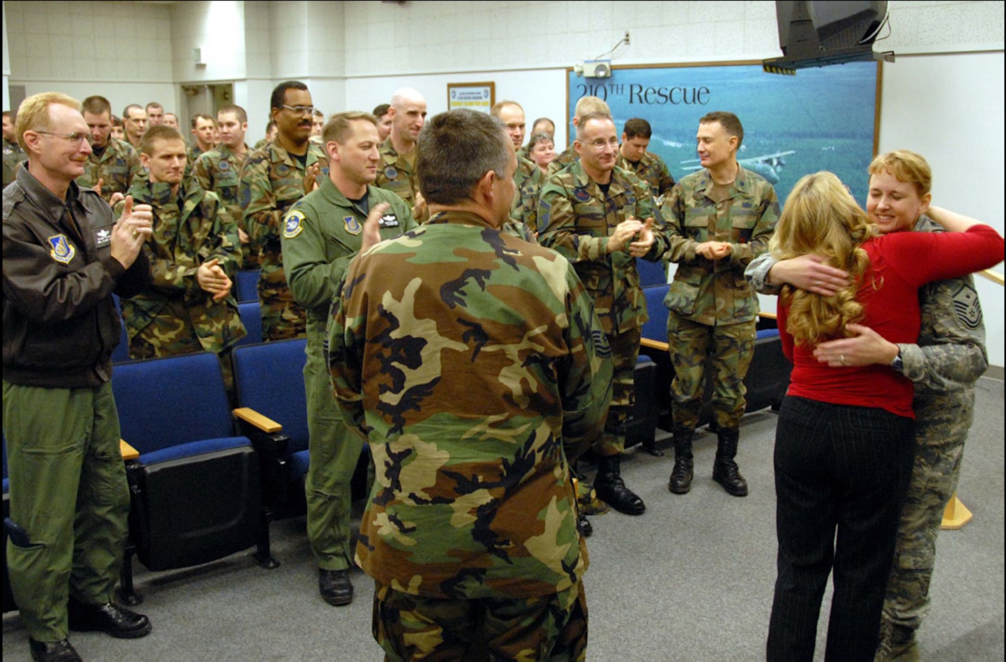 A standing ovation. After having been presented with tokens of gratitude from First Sergeant Barbara Jackson and commanders Lt. Col. Andrew Mamrol and Lt. Col. Mark Hedlund, volunteer Colette M. Moring gets a standing ovation from those present as she shares a hug with Jackson. The December ceremony recognized Moring’s many efforts supporting Alaska’s deployed Guard members.