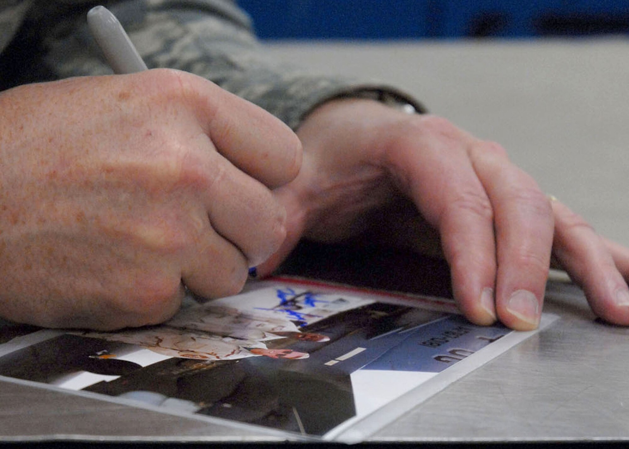 Chief Master Sgt. of the Air Force Rodney J. McKinley signs a photograph during his March 24 visit to Kunsan Air Base, South Korea. (U.S. Air Force photo/Staff Sgt. Araceli Alarcon) 
