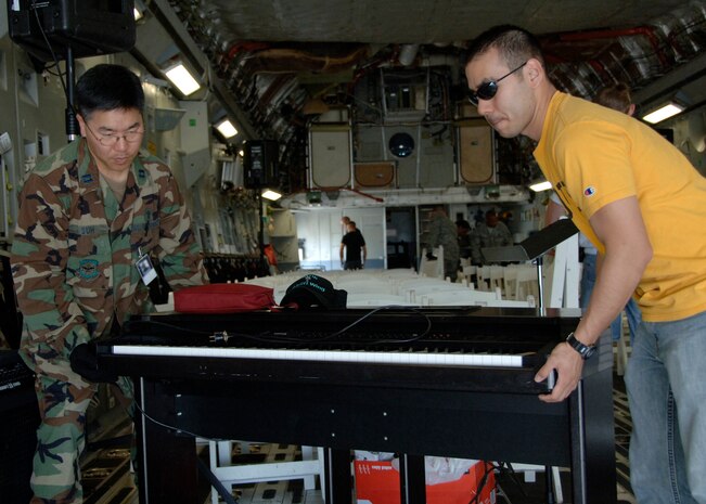 Chaplain (Capt.) David Suh and 2nd Lt. Norman Yu move a piano into a Charleston C-17 on the flightline Saturday for the Easter sunrise service. Chaplain Suh is with the 437th Mission Support Group and Lieutenant Yu is the 437th Aerial Port Squadron Officer in Charge of Air Terminal Operations. (U.S. Air Force photo/Airman 1st Class Katie Gieratz)