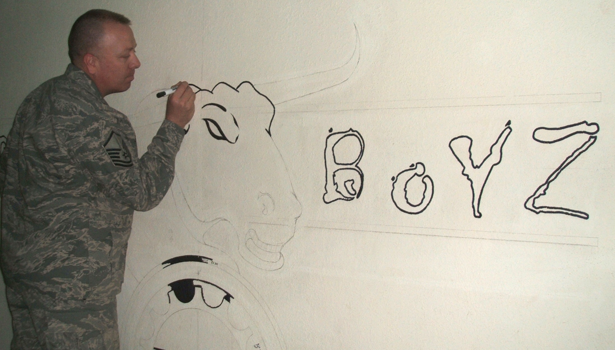 Master Sgt. Steven Sandy, 332nd Expeditionary Civil Engineer member, continues work on a CE heavy equipment mural.  Since their arrival, the deployed 21st Civil Engineer Squadron members have poured 1,894 cubic meters of concrete to increase aircraft parking and maintenance space on the base’s flightline. The Airmen have also enabled the fixed/rotary wing hot pit areas for multiple weapons systems and bolstered close air support by 20 percent. They have also completed taxiway repairs, conducting 386 small repairs to prevent combat sortie delays. They have also built a 4,000 square-foot concrete pad for a munitions storage area, foreign object and debris checkpoint, reducing FOD hazards by 73 percent to safeguard $1.9 million in assets. Currently, the members are working on projects to increase the unmanned aerial vehicle footprint in this area of responsibility. Sergeant Sandy is deployed from Peterson Air Force Base, Colo. (U.S. Air Force photo)