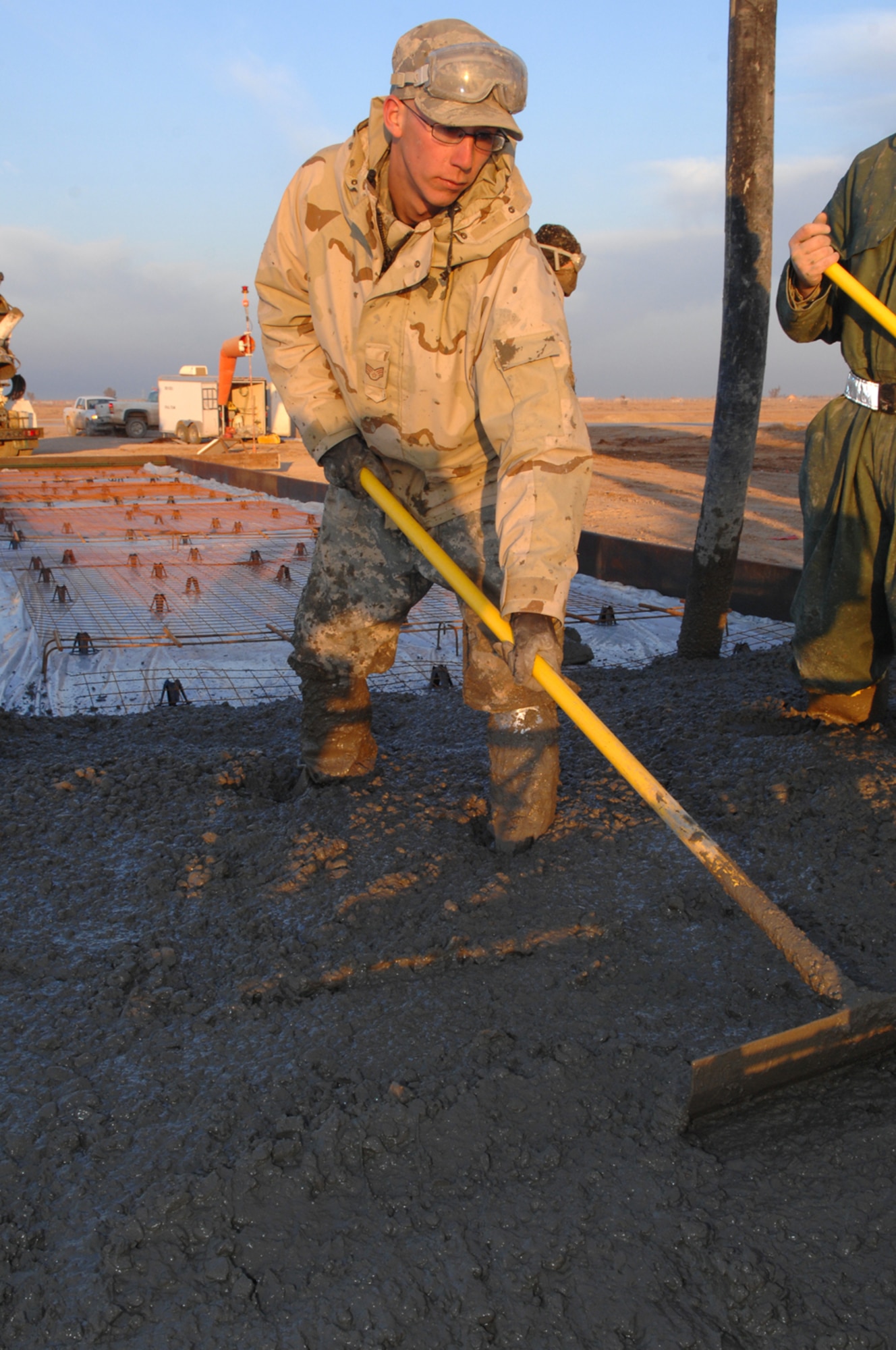 Airman 1st Class Jonathan Kidwell, 332nd Expeditionary Civil Engineer Squadron, evens out concrete on the Balad Air Base tarmac in Iraq. Since their arrival, the deployed 21st Civil Engineer Squadron members have poured 1,894 cubic meters of concrete to increase aircraft parking and maintenance space on the base’s flightline. The Airmen have also enabled the fixed/rotary wing hot pit areas for multiple weapons systems and bolstered close air support by 20 percent. They have also completed taxiway repairs, conducting 386 small repairs to prevent combat sortie delays. They have also built a 4,000 square-foot concrete pad for a munitions storage area, foreign object and debris checkpoint, reducing FOD hazards by 73 percent to safeguard $1.9 million in assets. Currently, the members are working on projects to increase the unmanned aerial vehicle footprint in this area of responsibility. Airman Kidwell is deployed from Peterson Air Force Base, Colo. (U.S. Air Force photo)