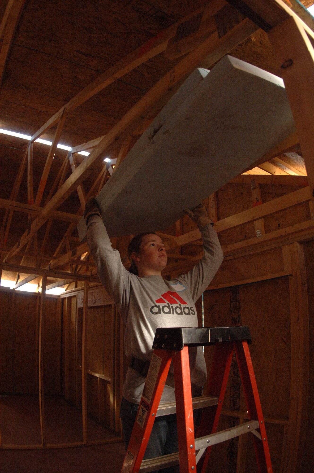 Cadet 4th Class Michelle Paranteau manuevers insulation in place, while helping build a home during her spring break, via Habitat for Humanity. Cadet Paranteau is one of 65 Air Force Academy cadets giving up their spring break this week, to build homes for the needy in Santa Fe, N.M.; Cody, Wyoming; El Paso, Texas; and Beaumont, Texas. (U.S. Air Force photo/John Van Winkle)  