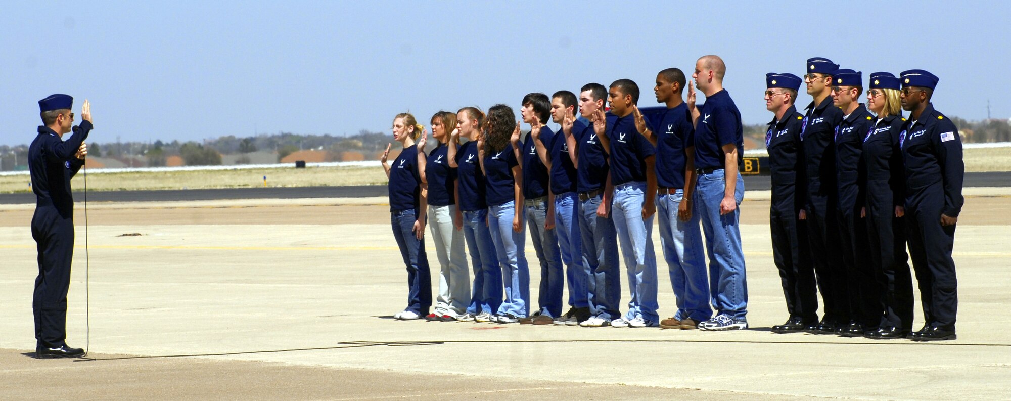 Lieutenant Colonel Greg Thomas, Thunderbird 1, leads a group of Delayed Entry Program participants as they swear “...to support and defend the Constitution of the United States.” The Thunderbirds conducted both an enlistment ceremony and a re-enlistment ceremony during their visit to San Angelo. (U.S. Air Force photo by Senior Airman Kamaile Chan)
