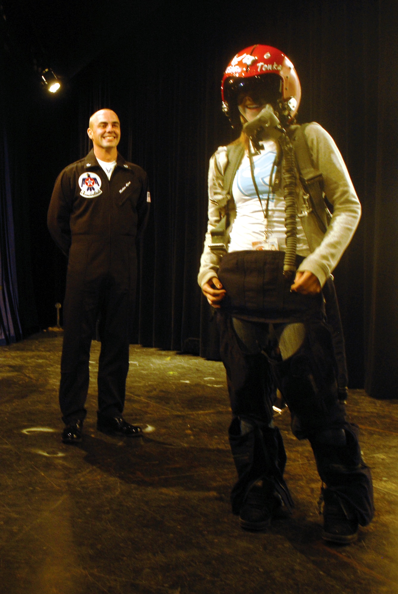 Technical Sergeant Matthew Alfreno, specialist section chief with the Thunderbirds, steps back after helping Molly Flynn, Central High School junior, don g-force gear March 14. (U.S. Air Force photo by Senior Airman Kamaile Chan)