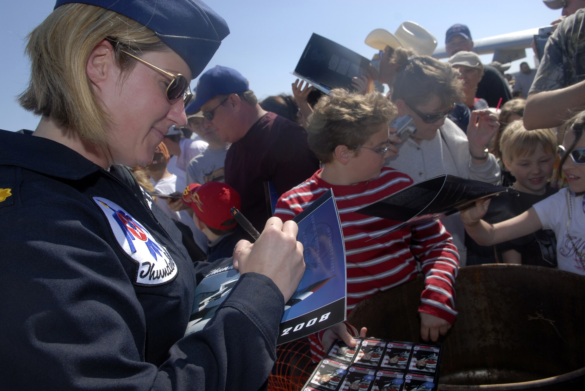 Maj. Samantha Weeks, Thunderbird 5 and lead solo, signs autographs during Air Fiesta ‘08. (U.S. Air Force photo by Senior Airman Kamaile Chan)