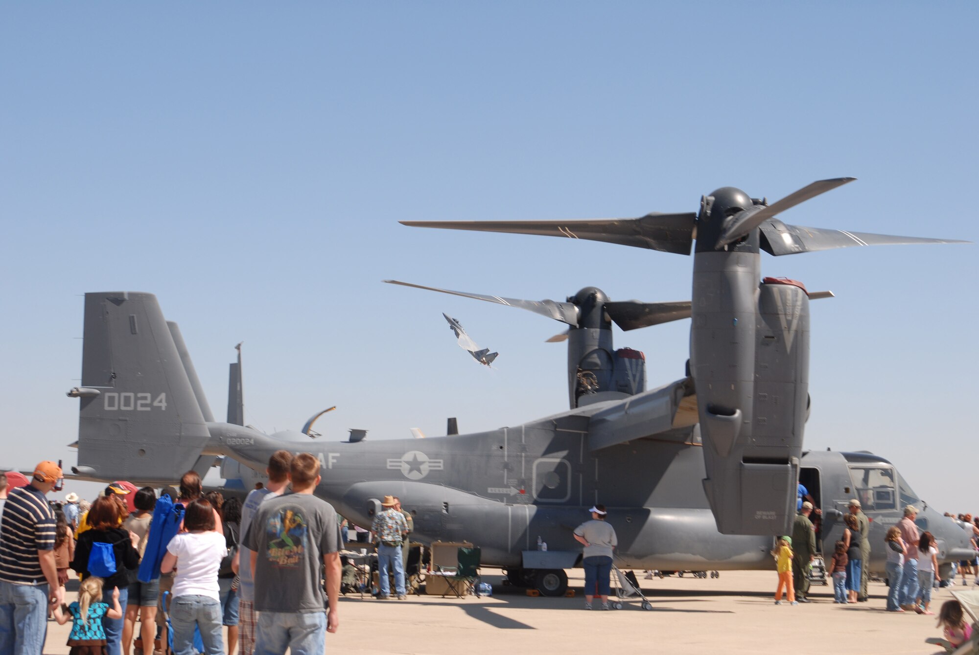 Crowds gather around a CV-22 Osprey as an F-15E Strike Eagle performs aerobatics in the background at Air Fiesta ‘08 March 15 at San Angelo Regional Airport Mathis Field. All told, there were 68 performing and static aircraft at Air Fiesta ‘08, including 18 aerial performances. (U.S. Air Force photo by Paul Martin).